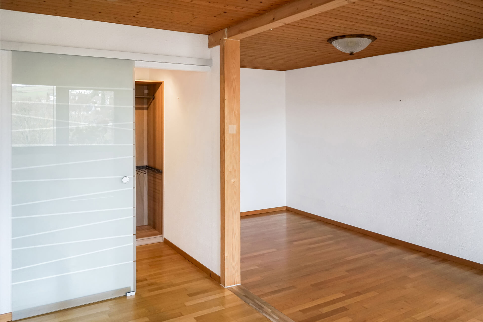 Heller Innenraum mit Holzdecke und Schiebetür