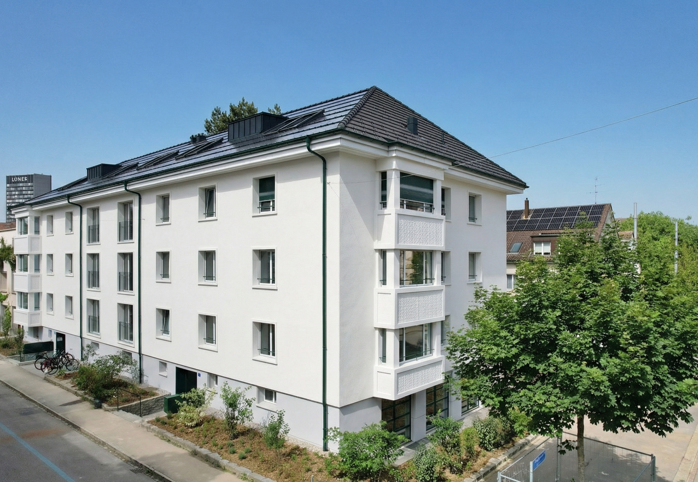Mehrfamilienhaus mit weißer Fassade und Walmdach