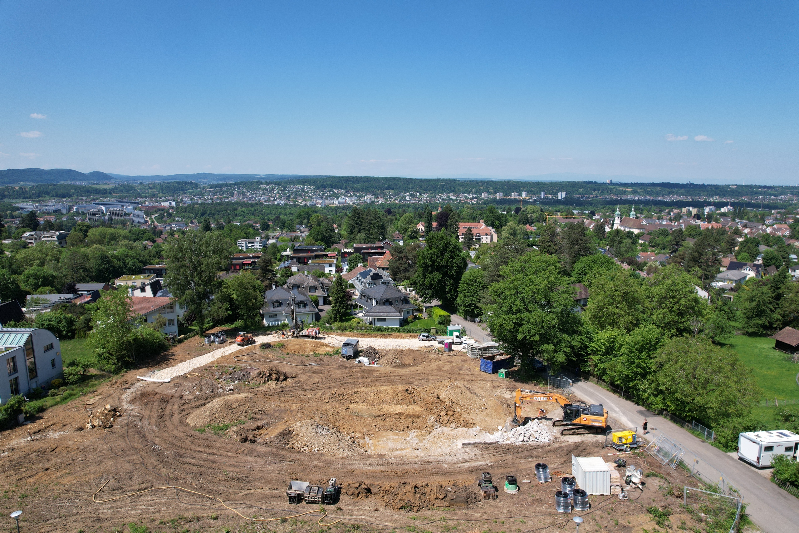 Luftaufnahme einer Baustelle in einem grünen Wohngebiet