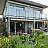 Moderne Hausfassade mit Balkon und Garten