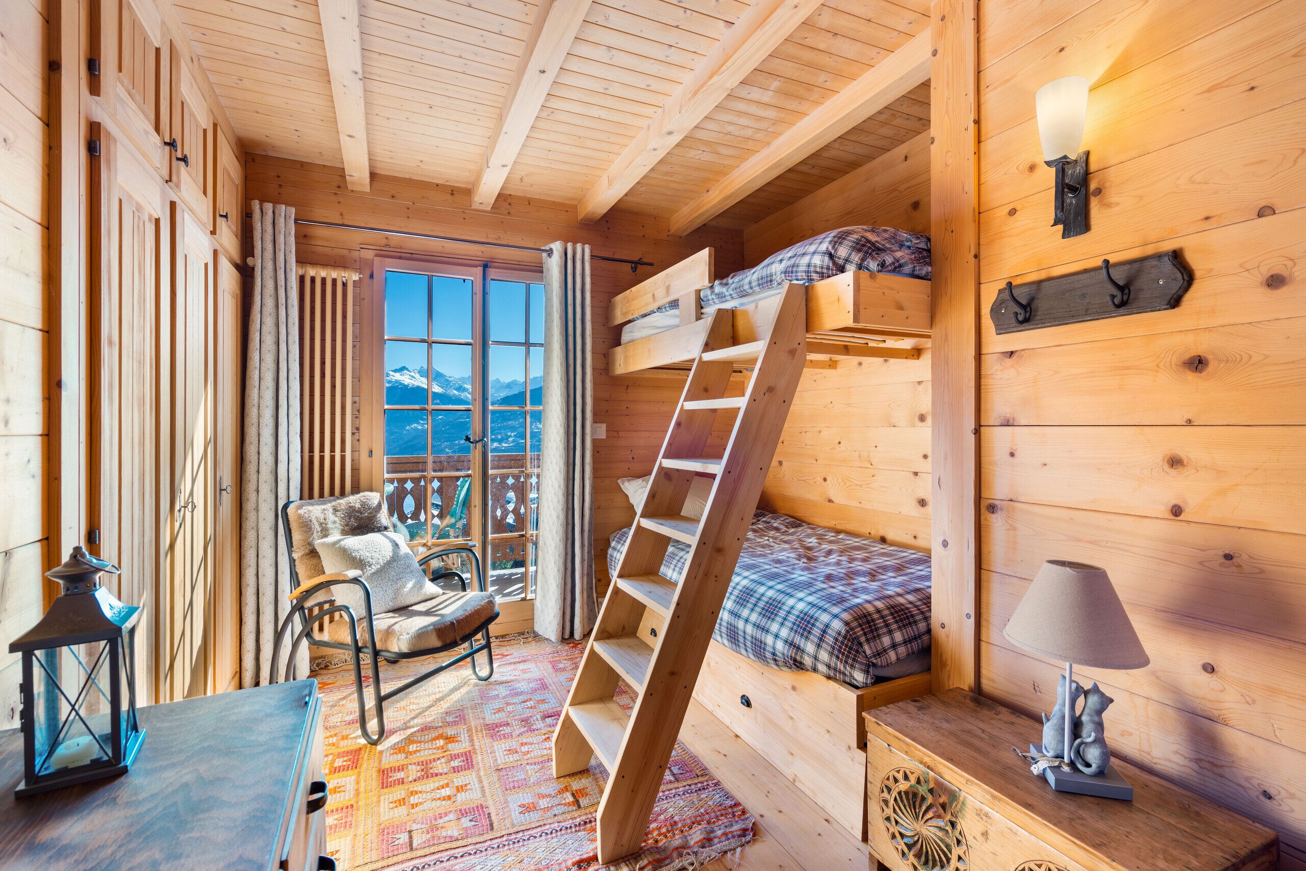 Gemütliches Holz-Schlafzimmer mit Etagenbett und Bergblick