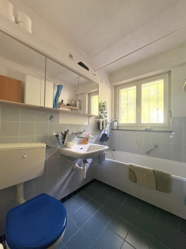Helles Badezimmer mit Badewanne und Fenster
