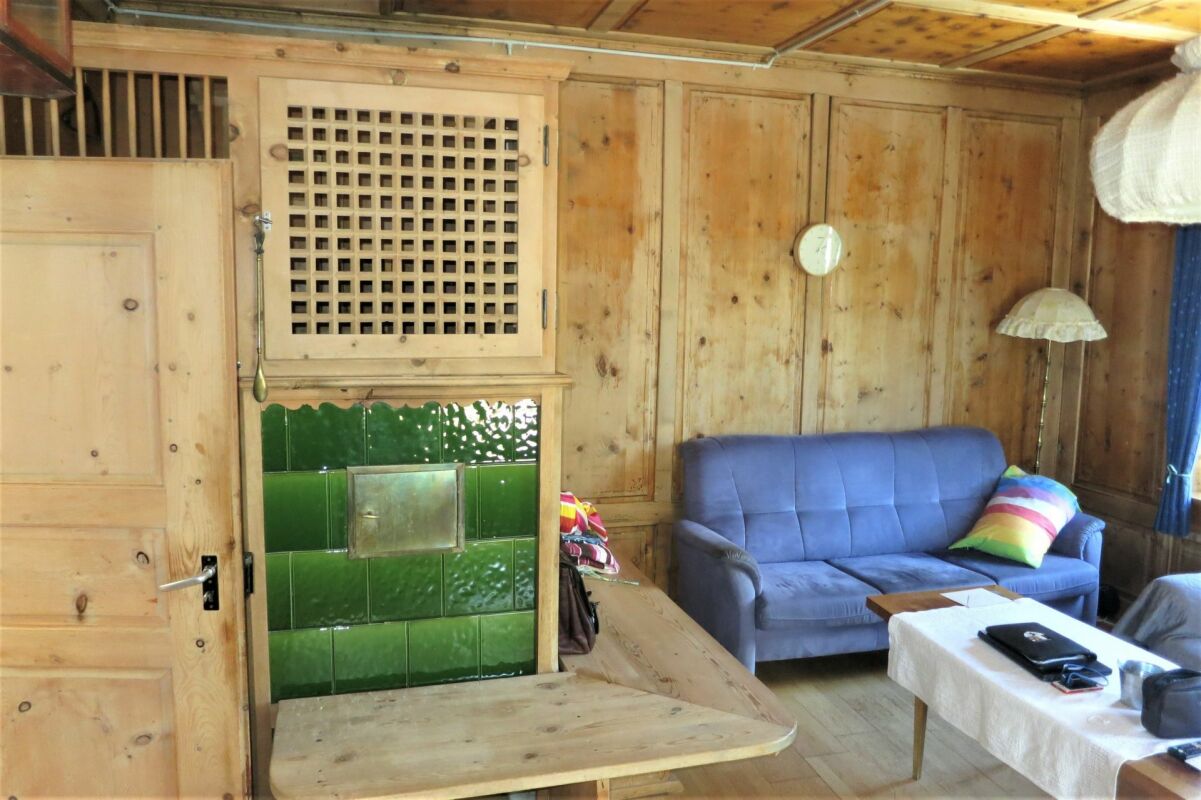 Gemütliches Holzwohnzimmer mit grünem Kachelofen