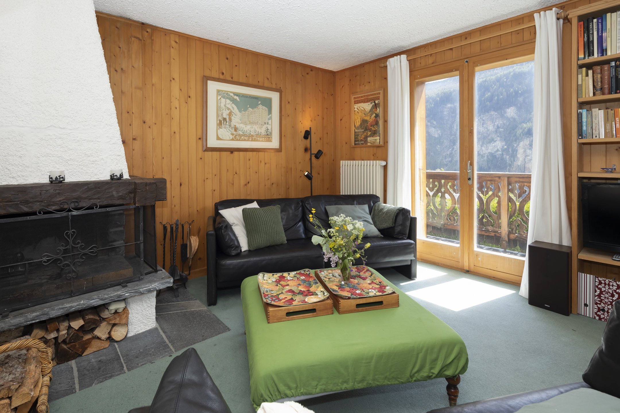 Gemütliches Wohnzimmer mit Kamin und Balkonblick