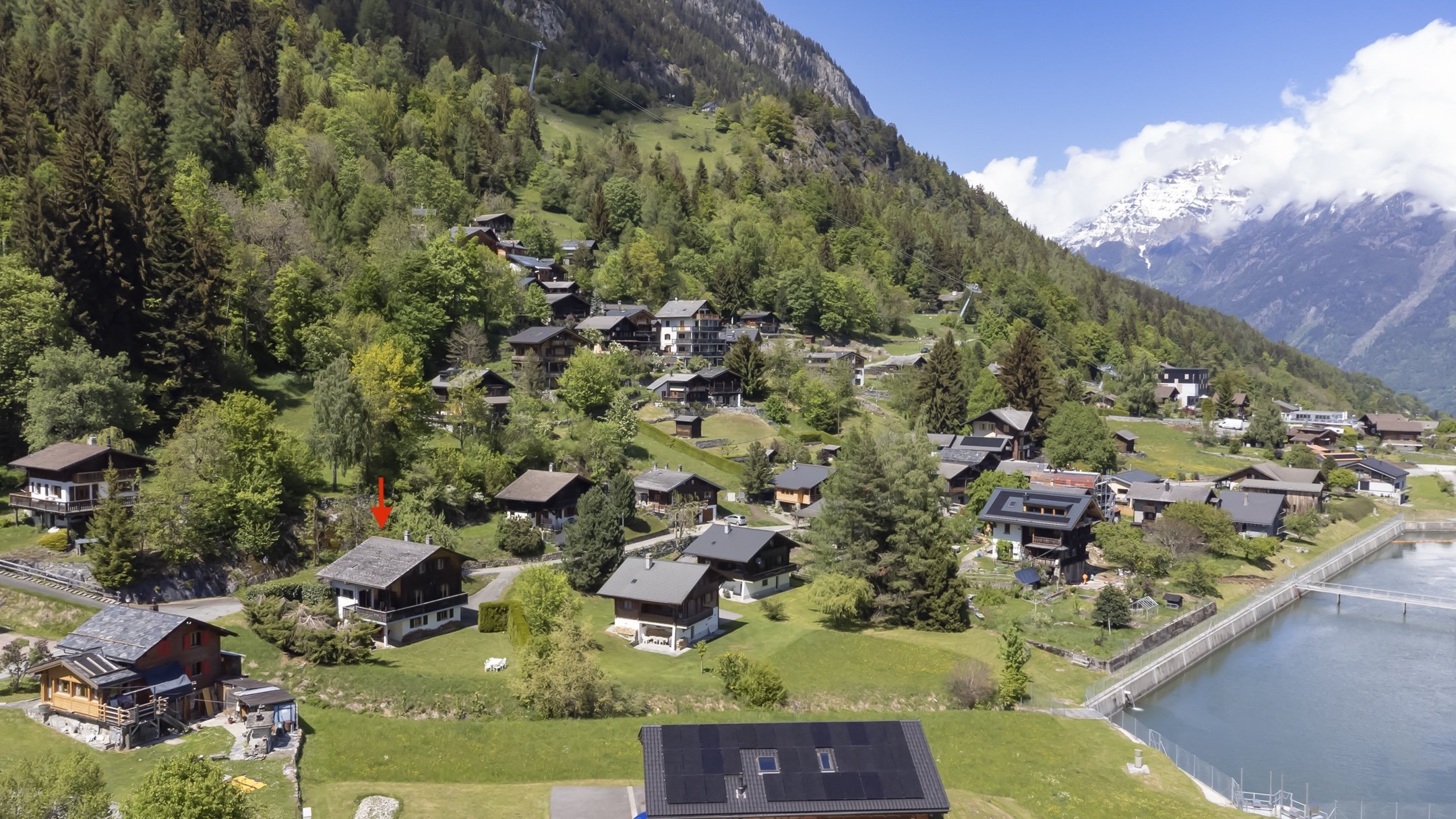 Luftaufnahme eines alpinen Dorfes am Berghang