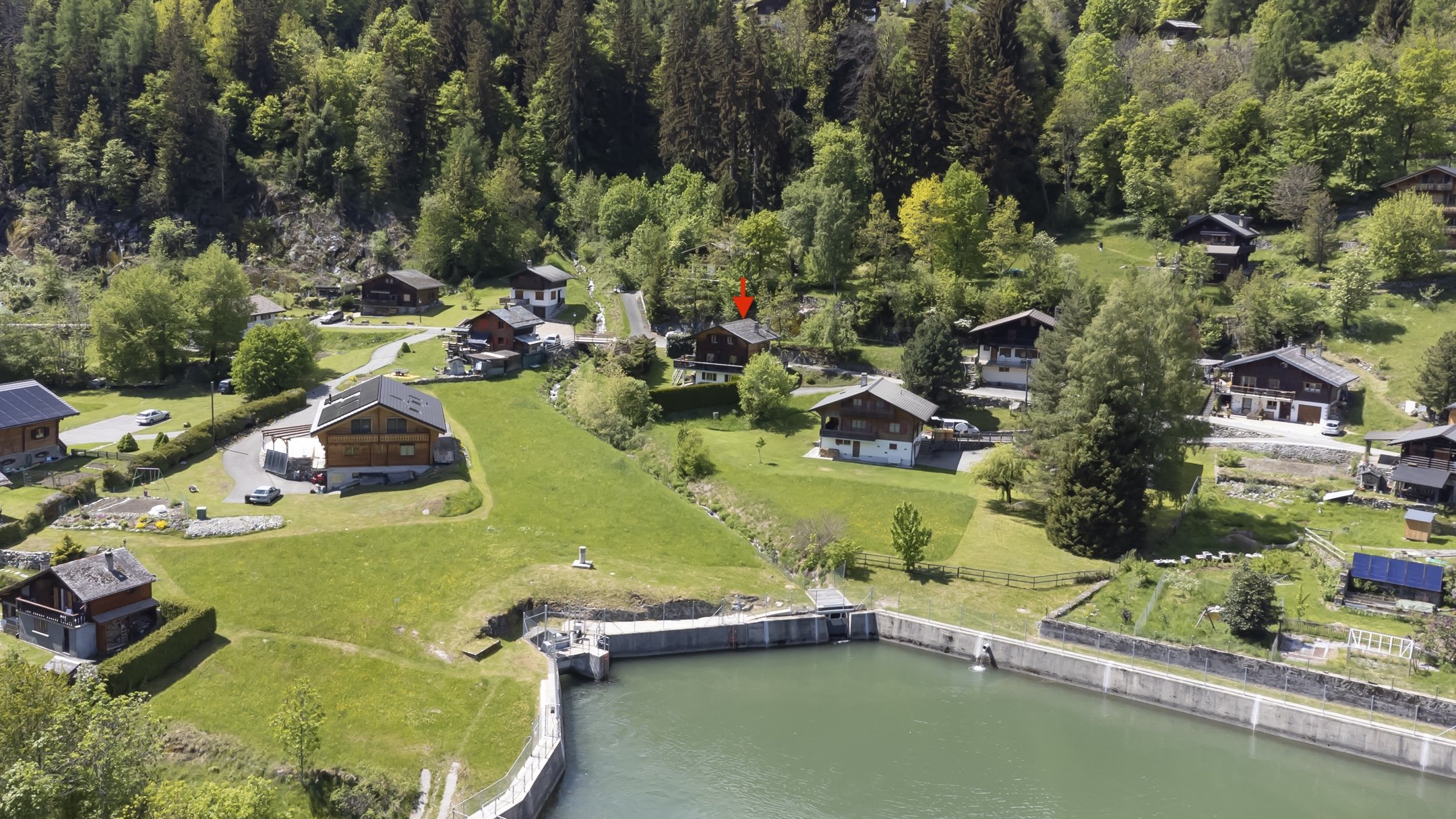 Luftaufnahme eines alpinen Wohngebiets am Wasser