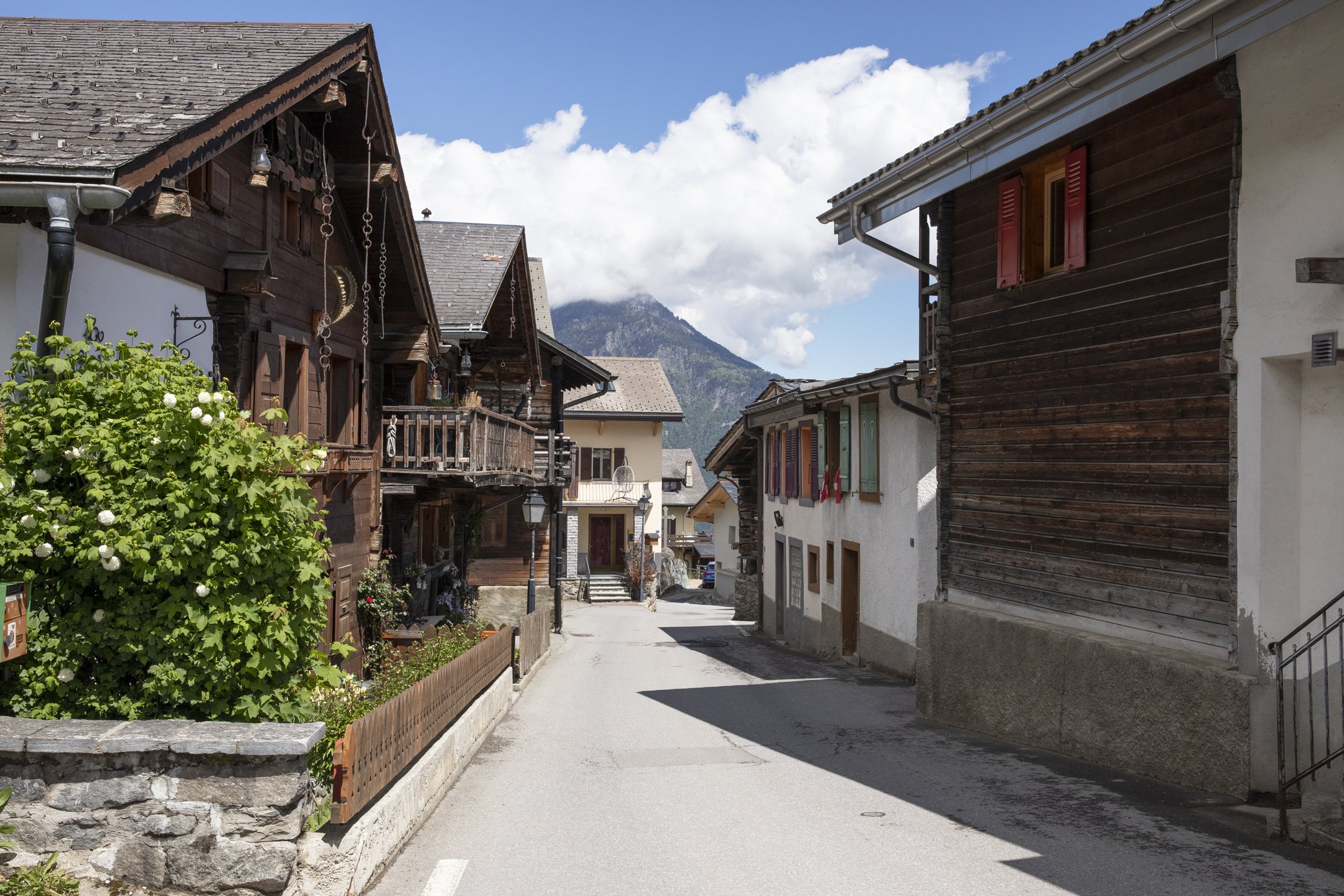 Alpine Dorfstraße mit traditionellen Holzhäusern