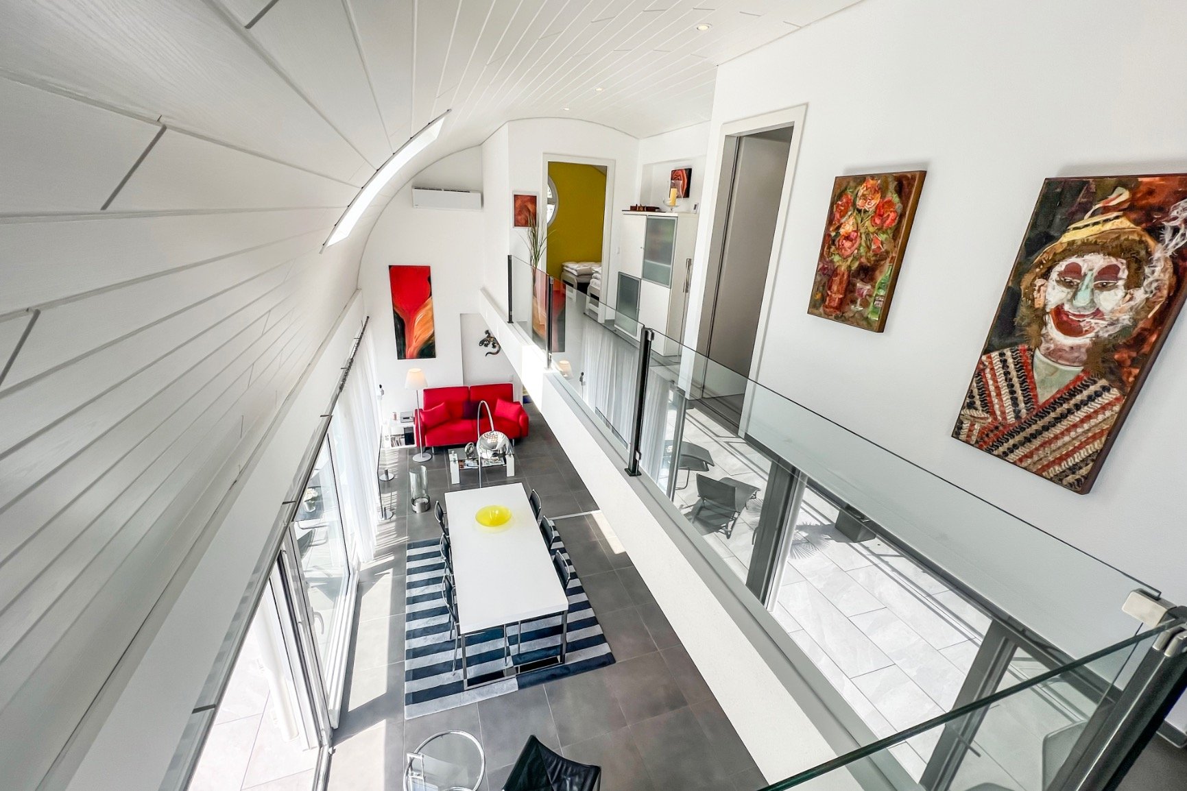Modernes Galerie-Wohn-/Essbereich mit Glasbrüstung