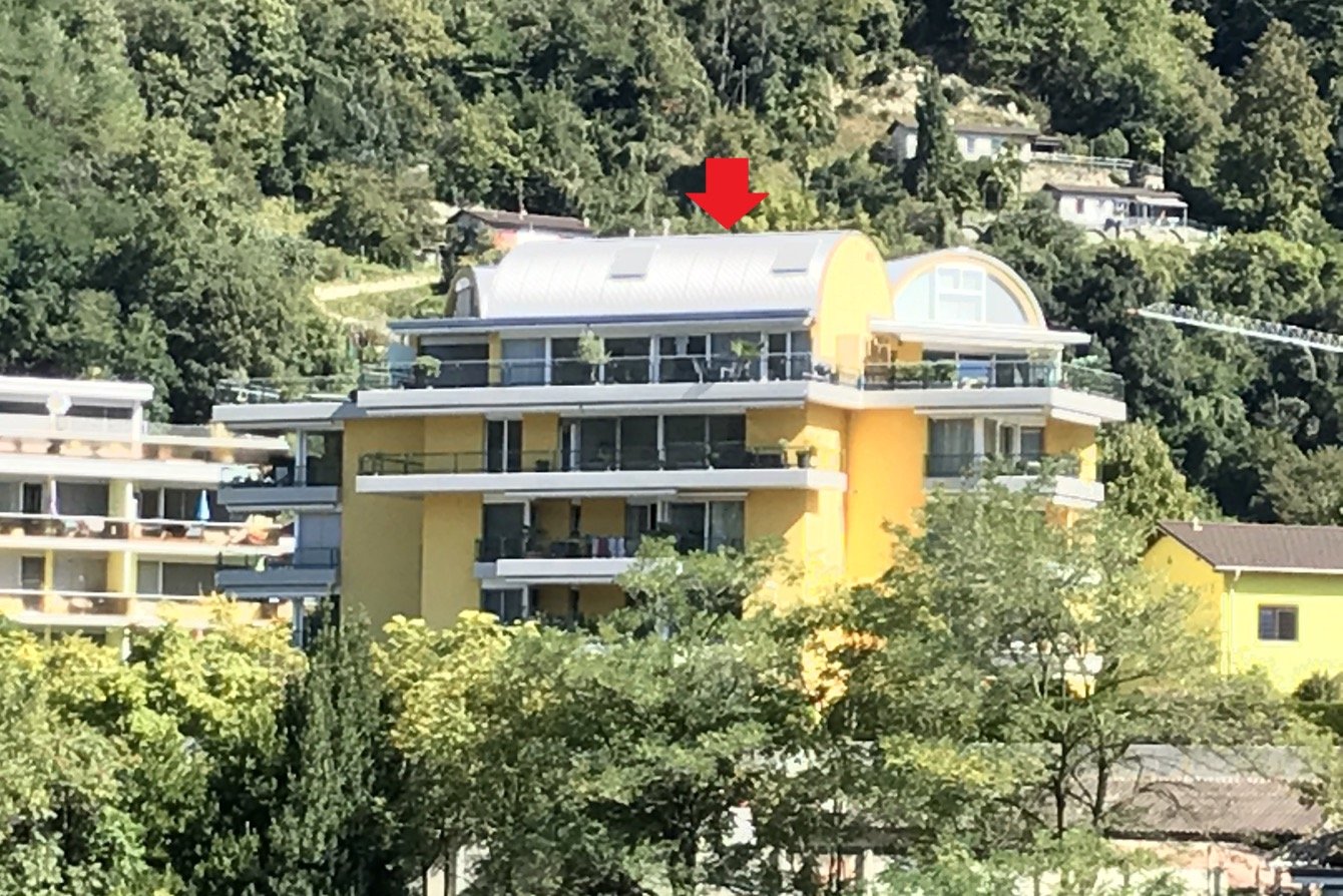 Gelbes Mehrfamilienhaus mit Dachterrasse