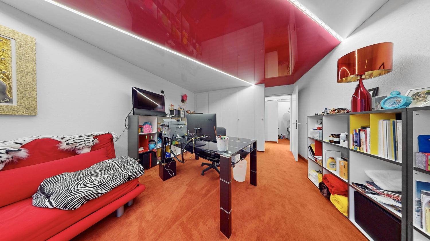 Modernes Arbeitszimmer mit roter Akzentdecke