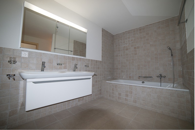 Badezimmer mit Wanne und Wandwaschtisch