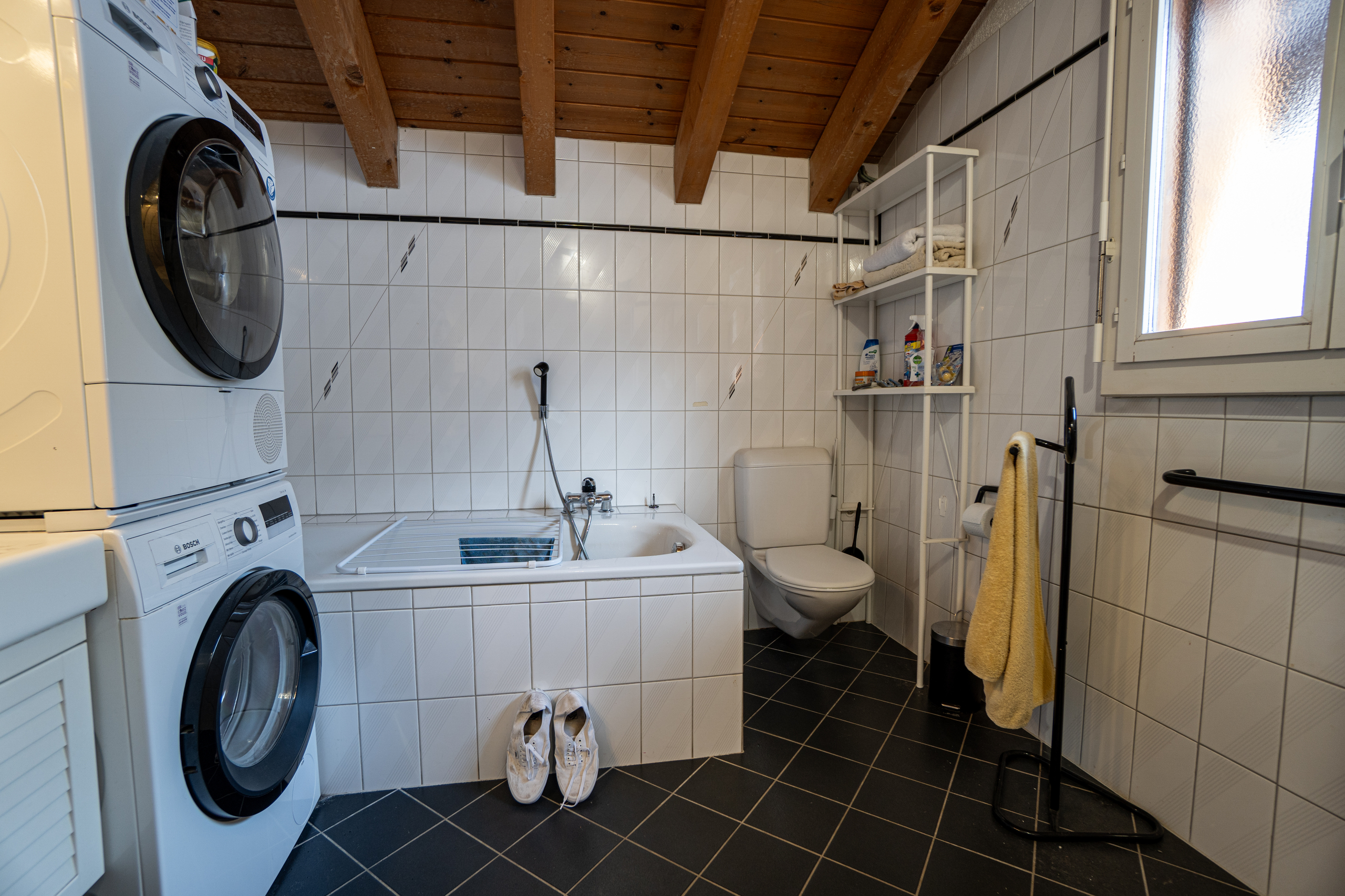 Hauswirtschaftsraum mit Badewanne und Waschturm
