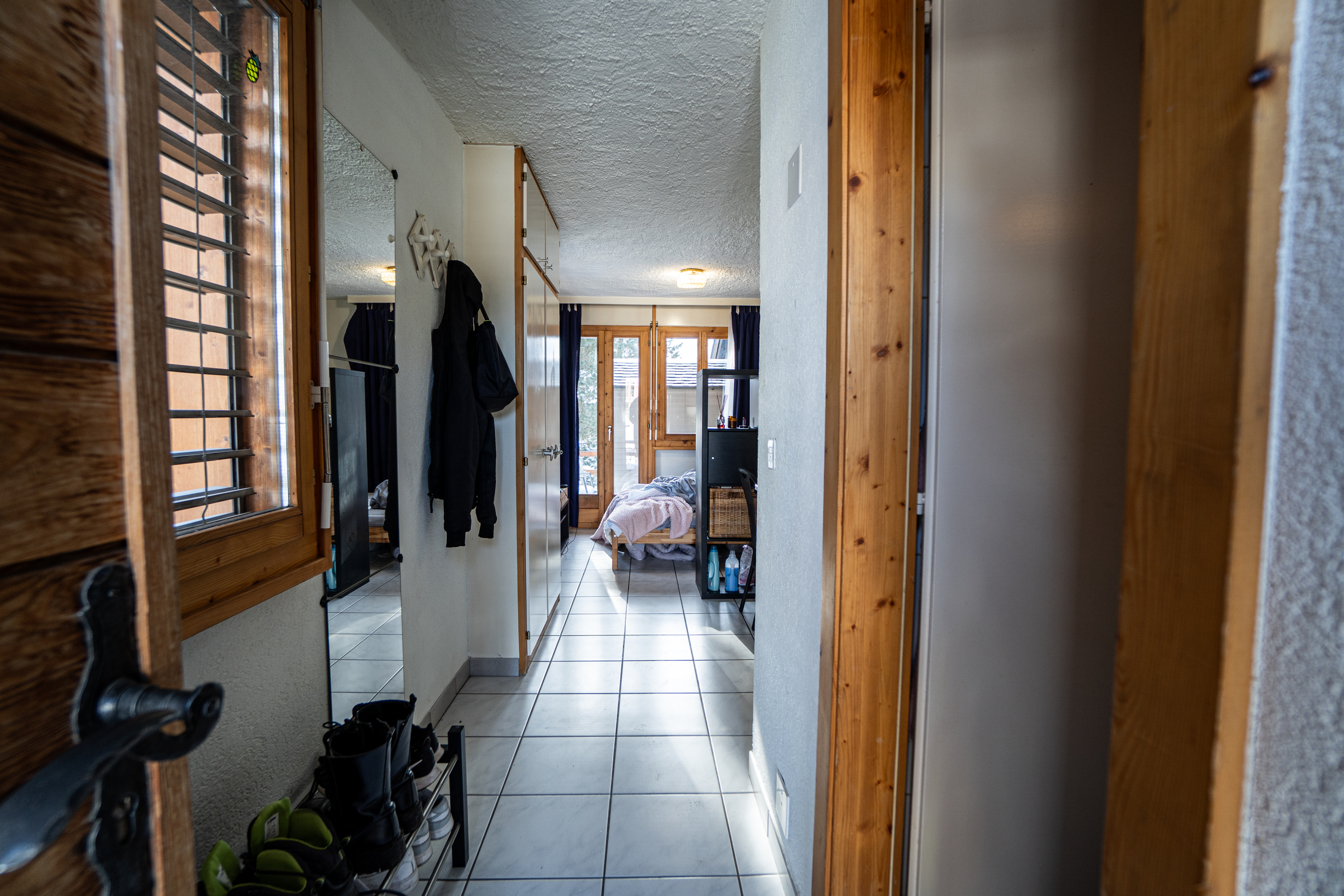 Schmaler Flur mit Blick in ein kleines Schlafzimmer