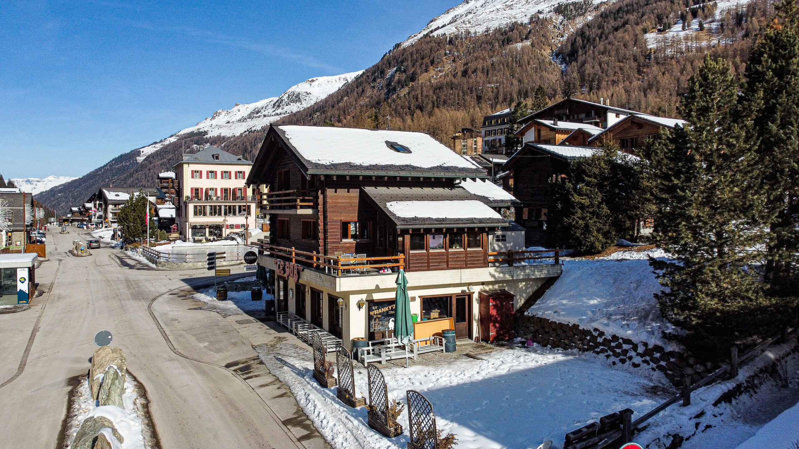 Alpines Gebäudeensemble mit Schnee und Bergen