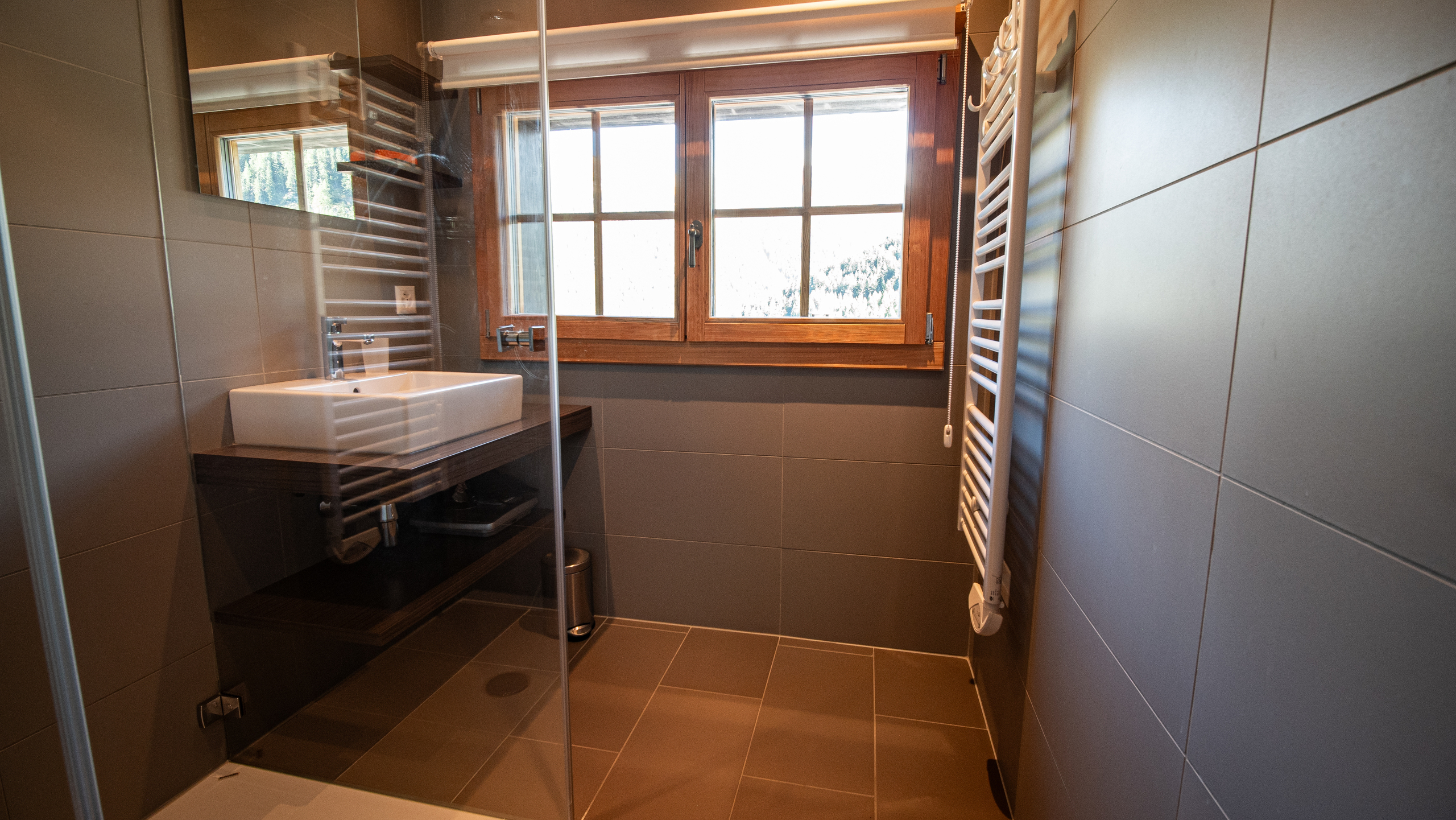 Modernes Badezimmer mit Dusche und Holzfenster