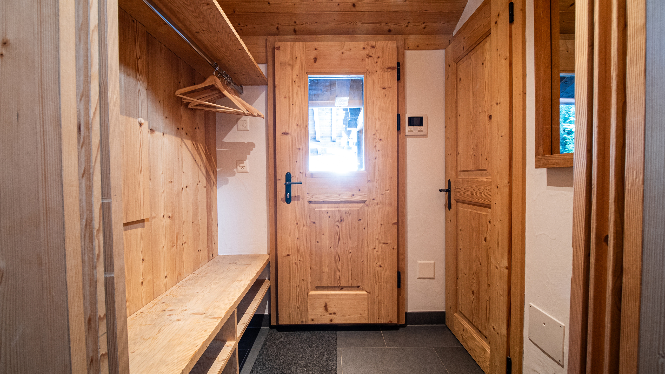 Holzverkleidete Garderobe mit Türbereich