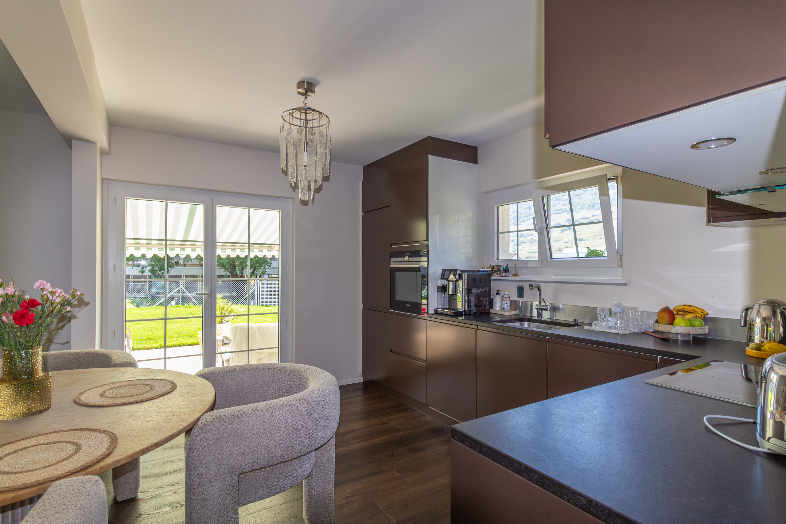 Moderne Küche mit Essbereich und Gartenblick