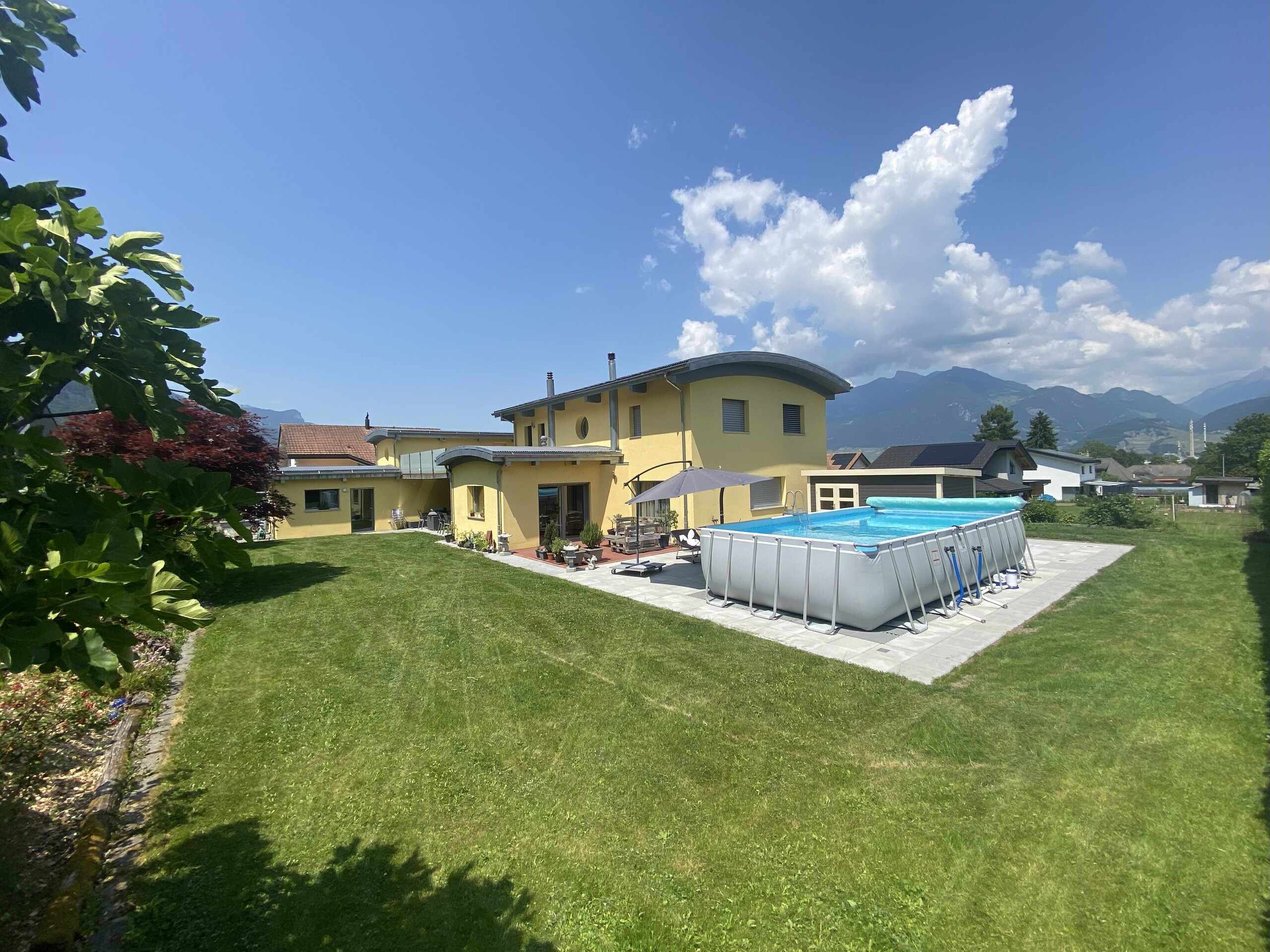 Gartenansicht mit Aufstellpool und Bergblick