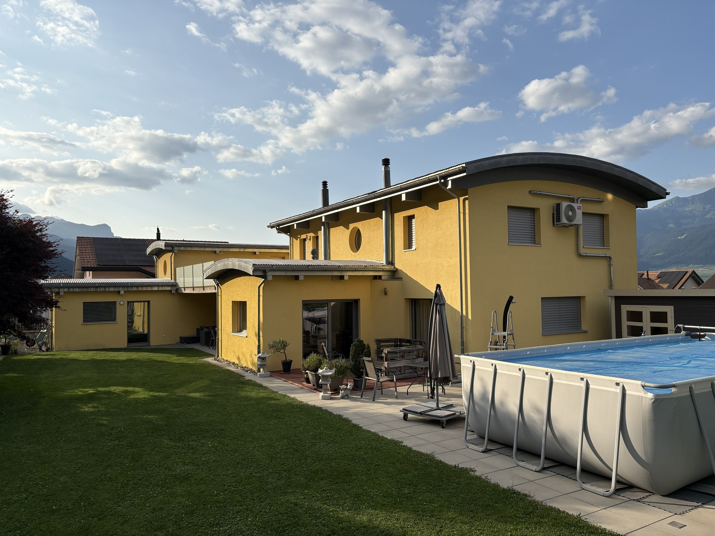 Außenansicht eines Einfamilienhauses mit Garten und Pool