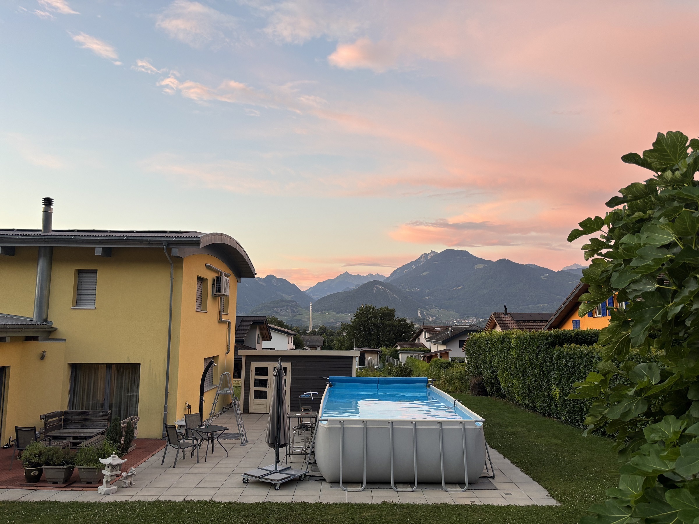 Garten mit Pool und Bergblick bei Sonnenuntergang
