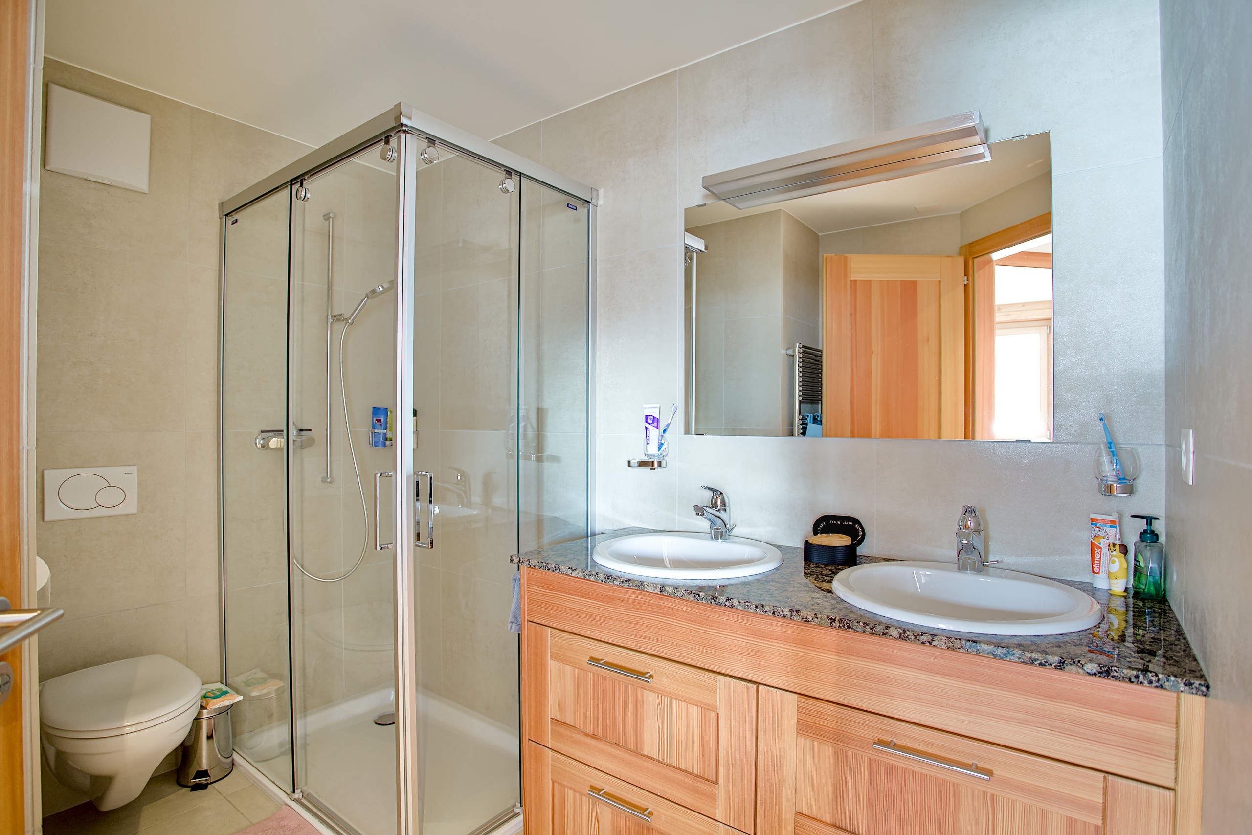 Modernes Badezimmer mit Doppelwaschtisch und Glasdusche