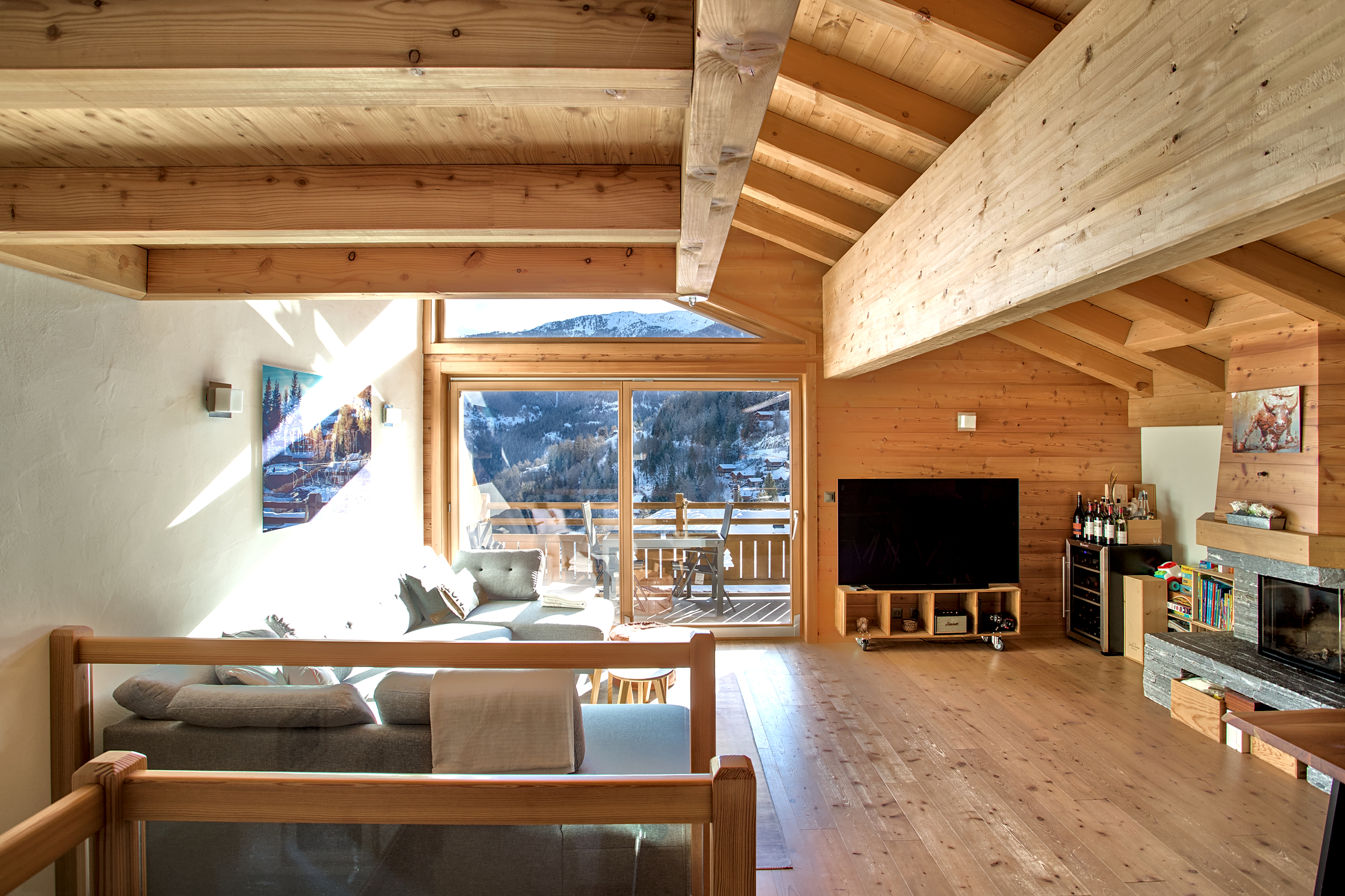 Helles alpines Wohnzimmer mit Holzdecke und Bergblick