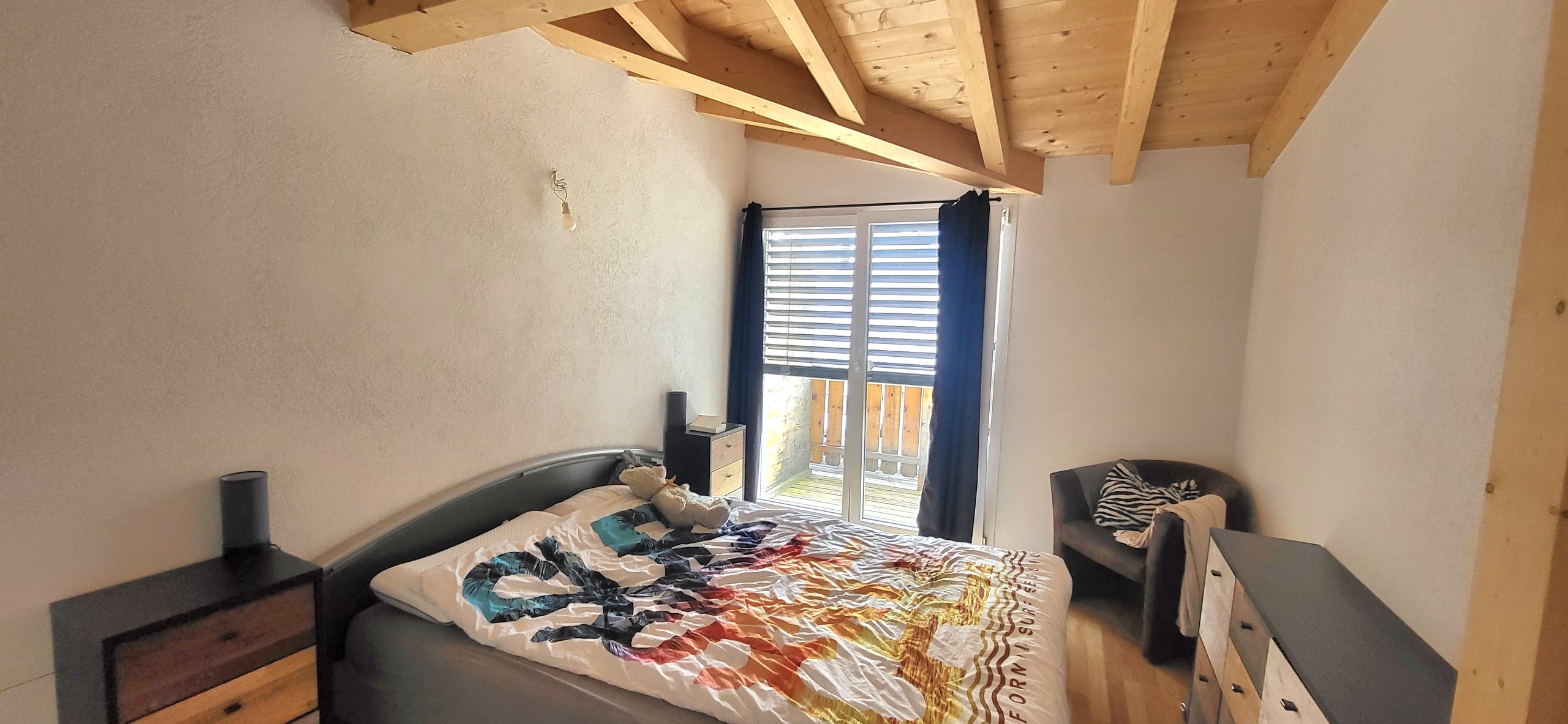 Gemütliches Schlafzimmer mit sichtbaren Holzbalken
