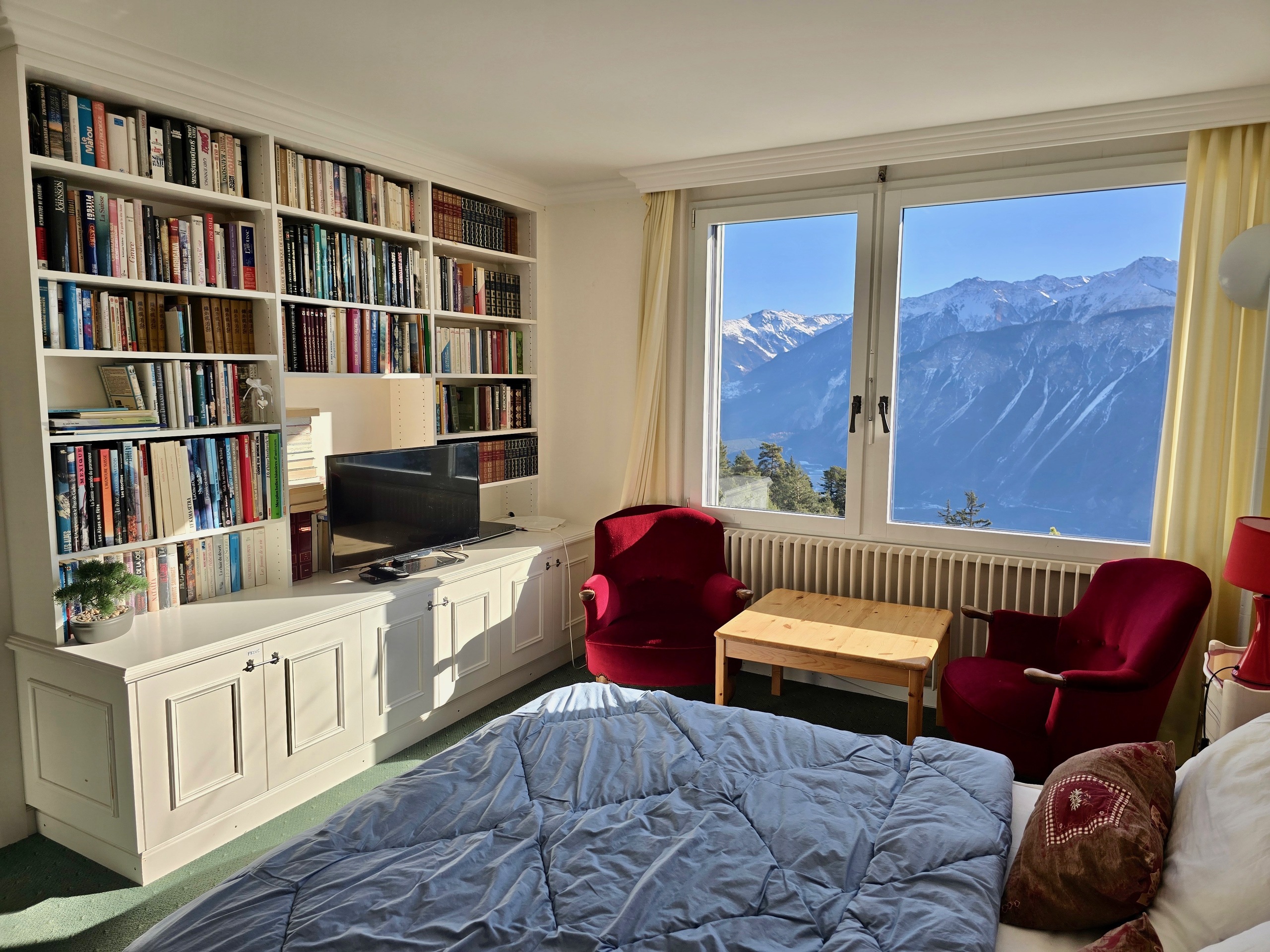 Schlafzimmer mit Bergblick und Bücherwand
