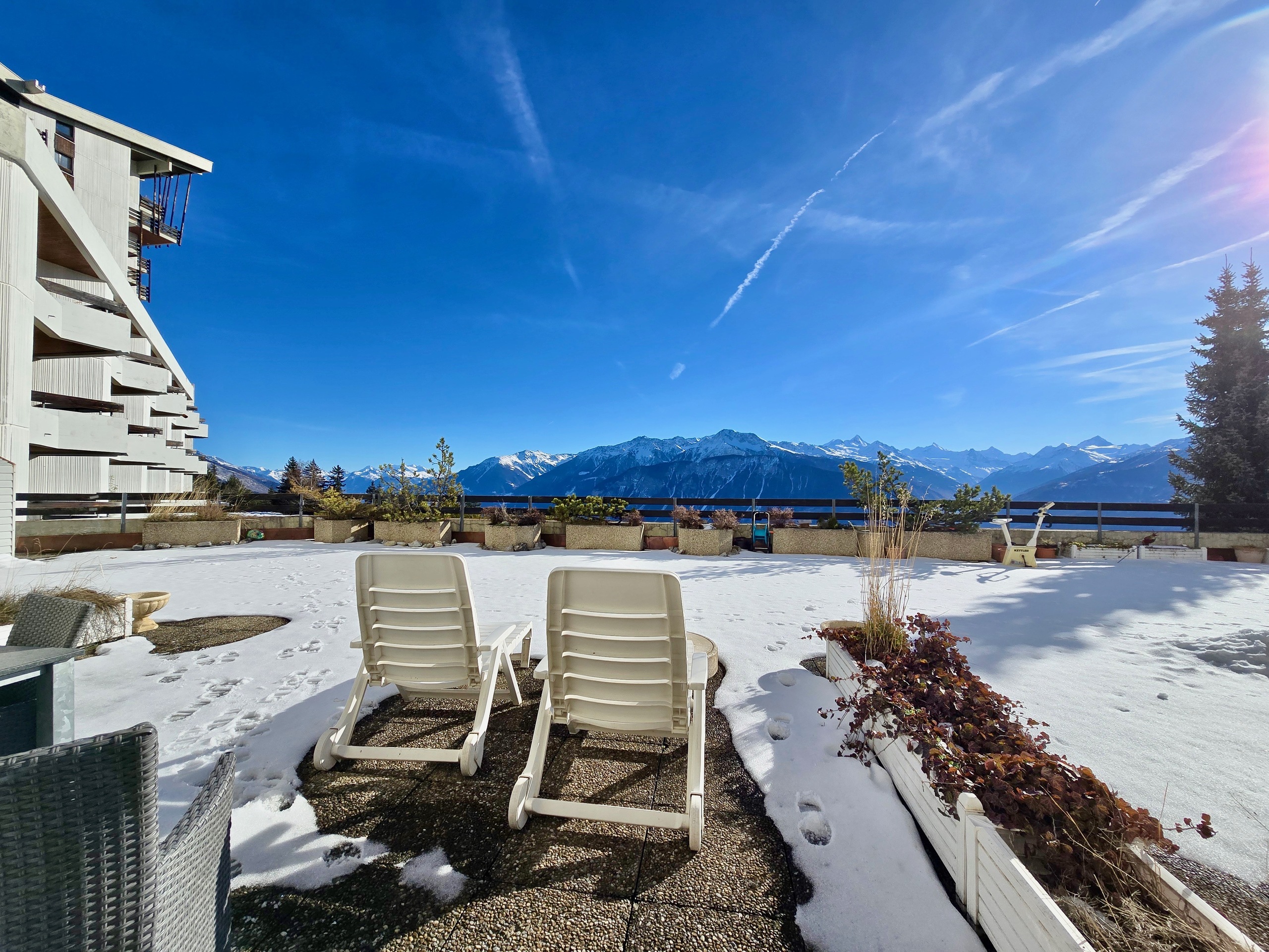 Schneebedeckte Dachterrasse mit Bergpanorama