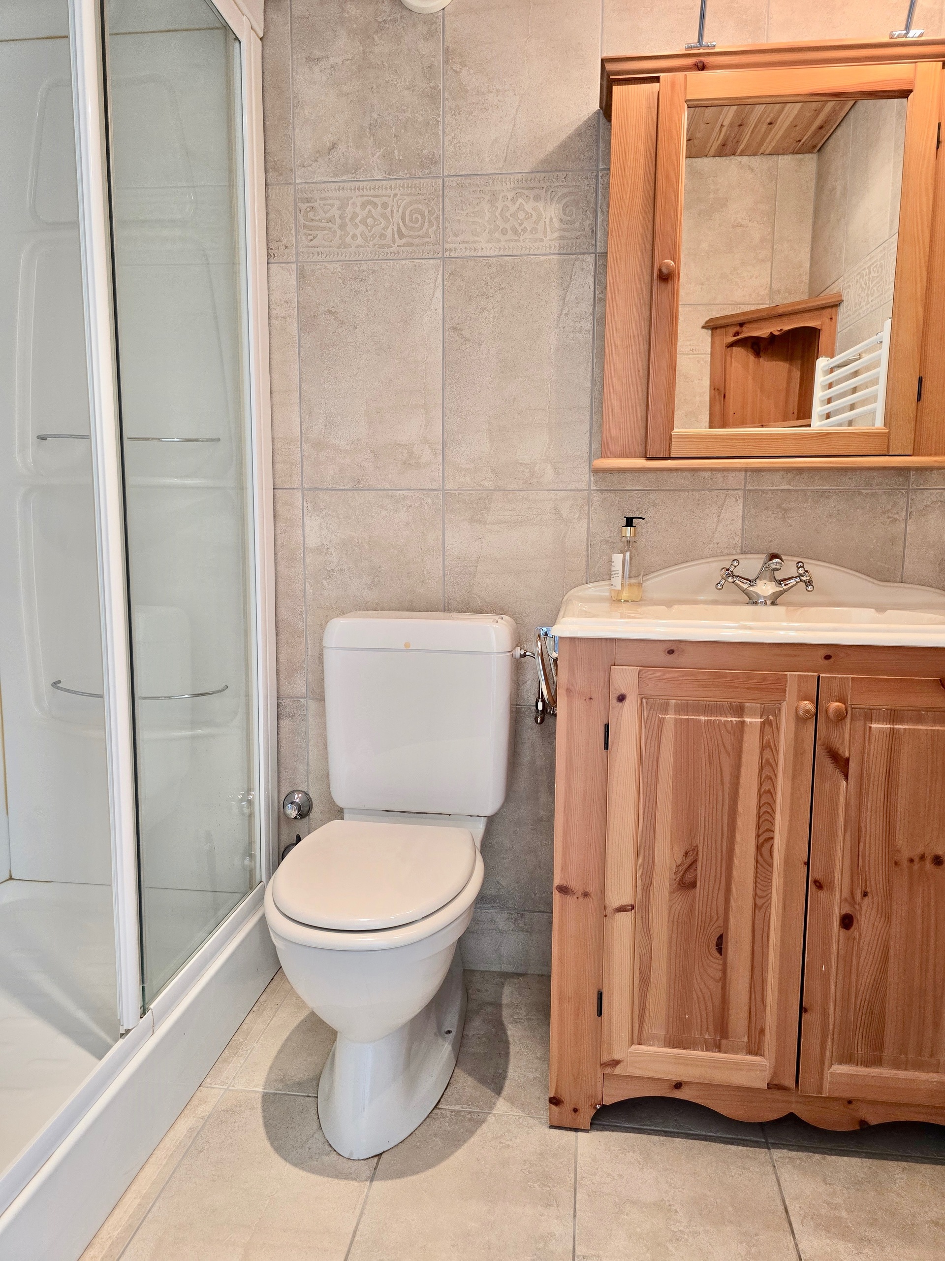 Kleines Badezimmer mit Dusche, WC und Holzwaschtisch