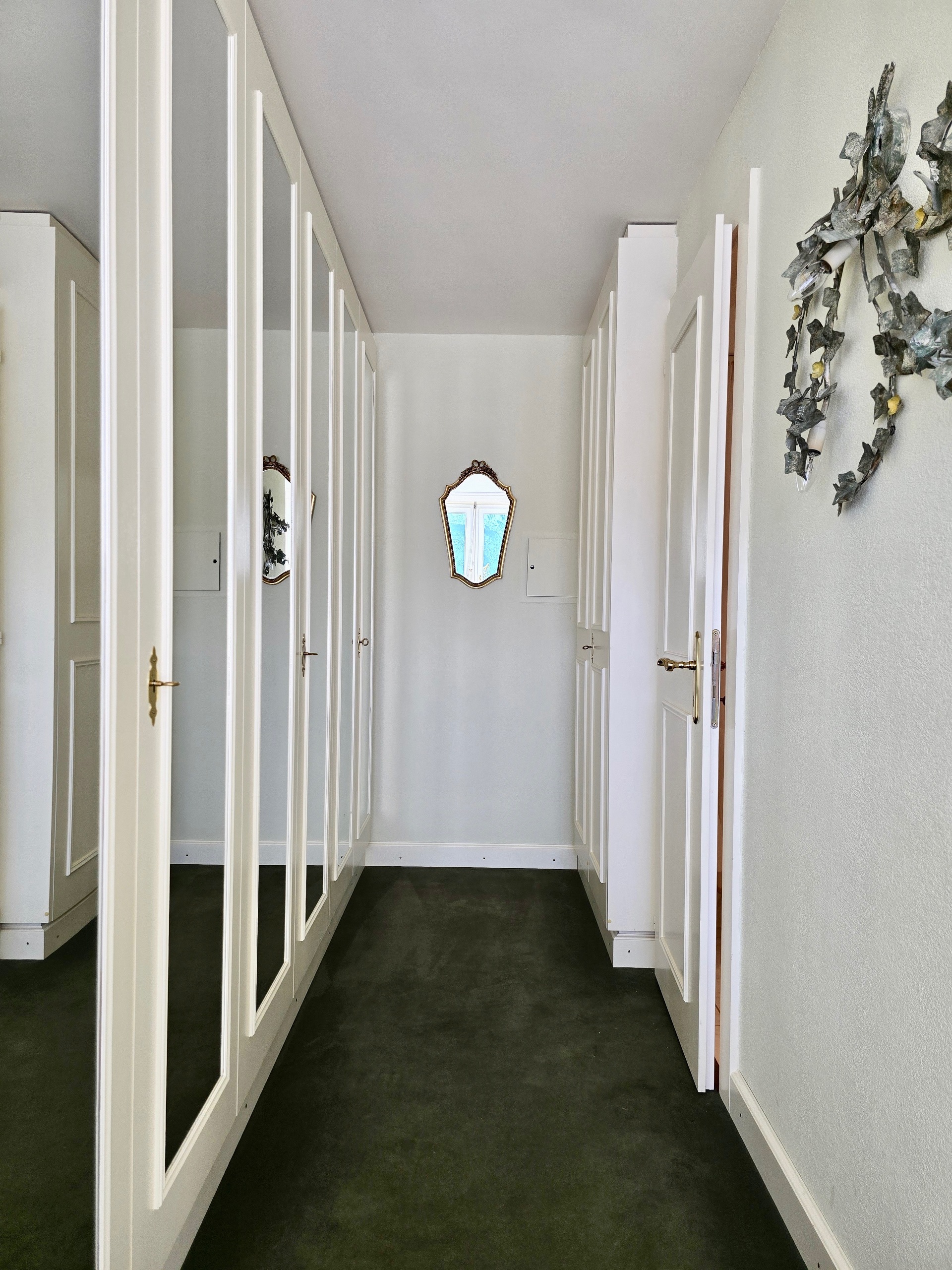 Schmaler begehbarer Flur mit Kleiderschrank und Spiegeln