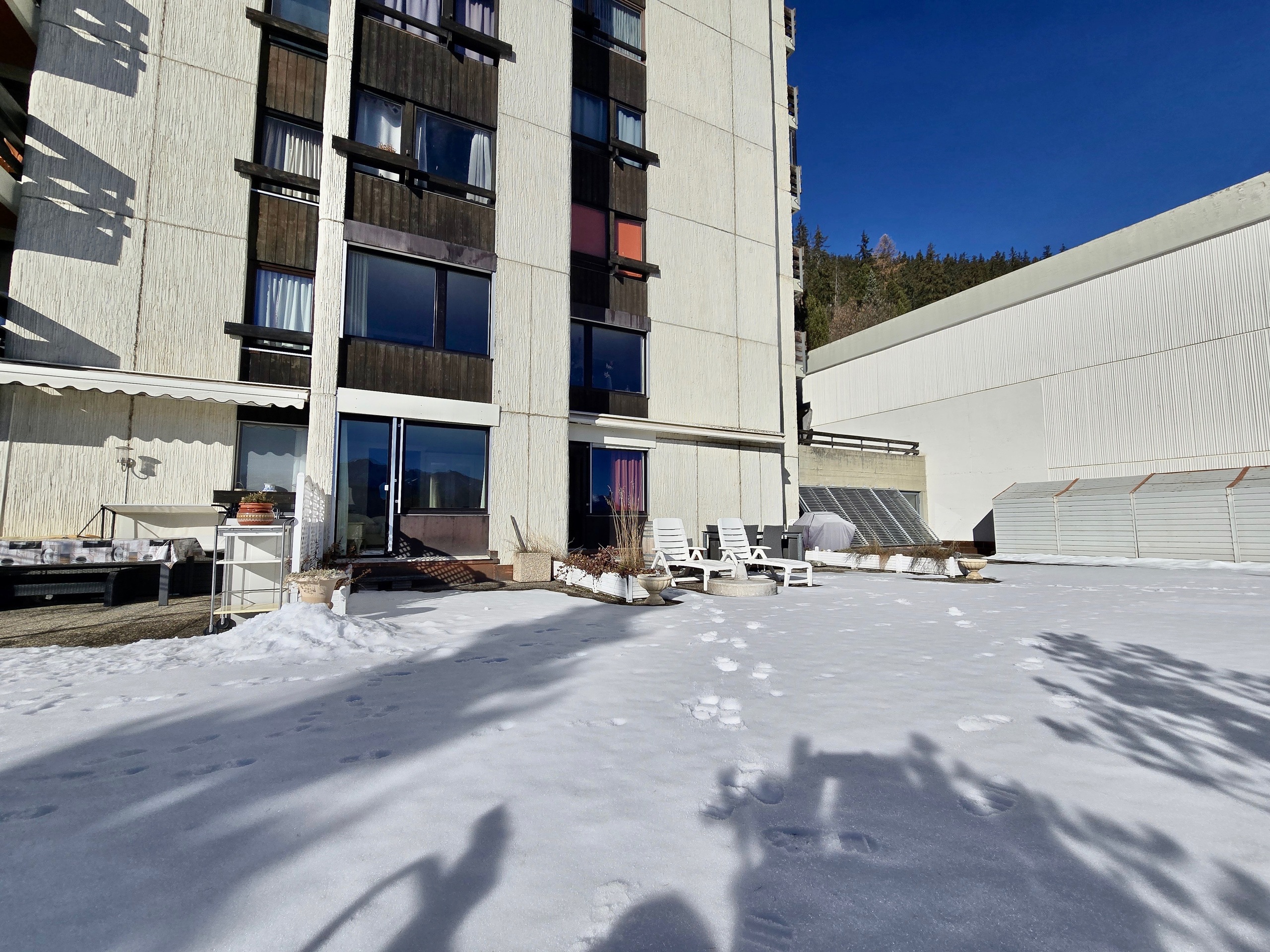 Außenansicht eines Wohngebäudes mit verschneiter Terrasse