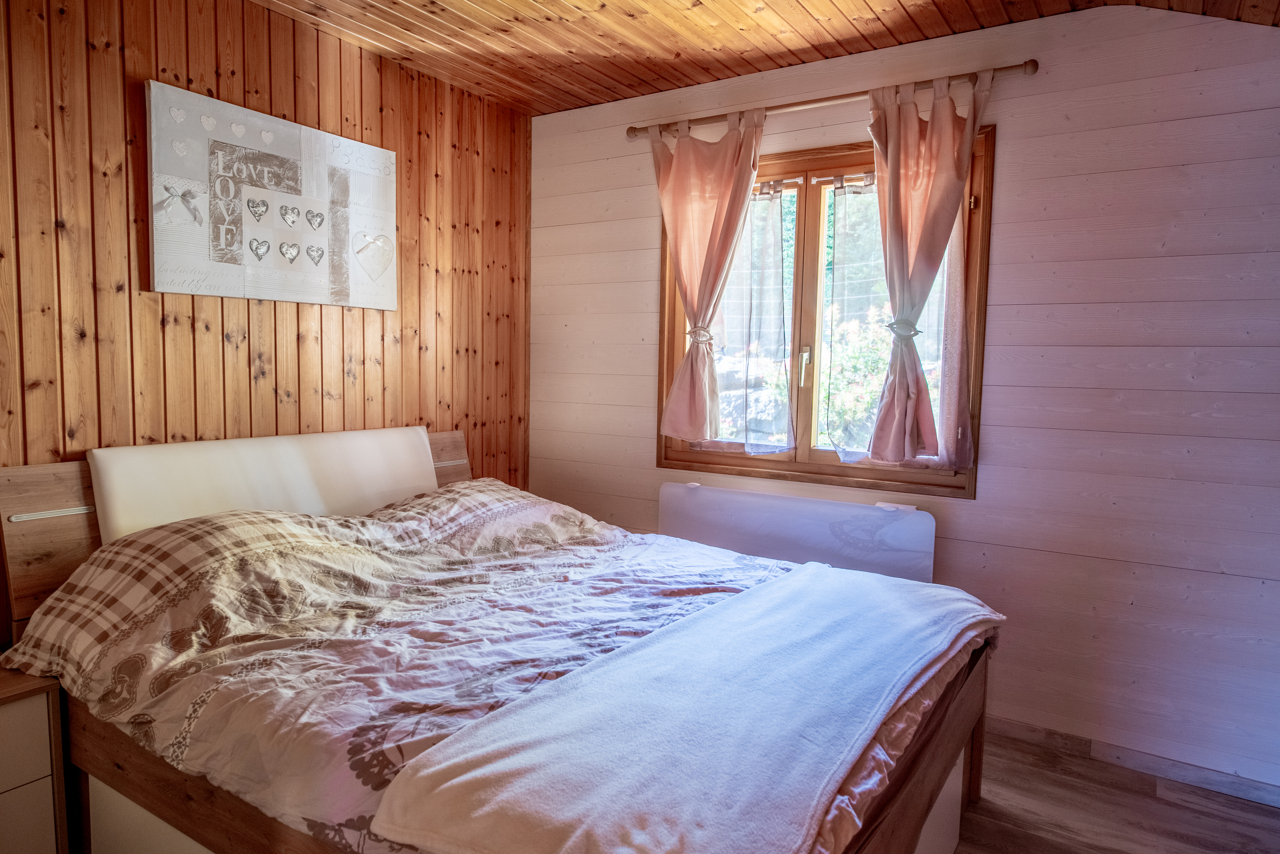 Gemütliches Schlafzimmer mit Holzverkleidung