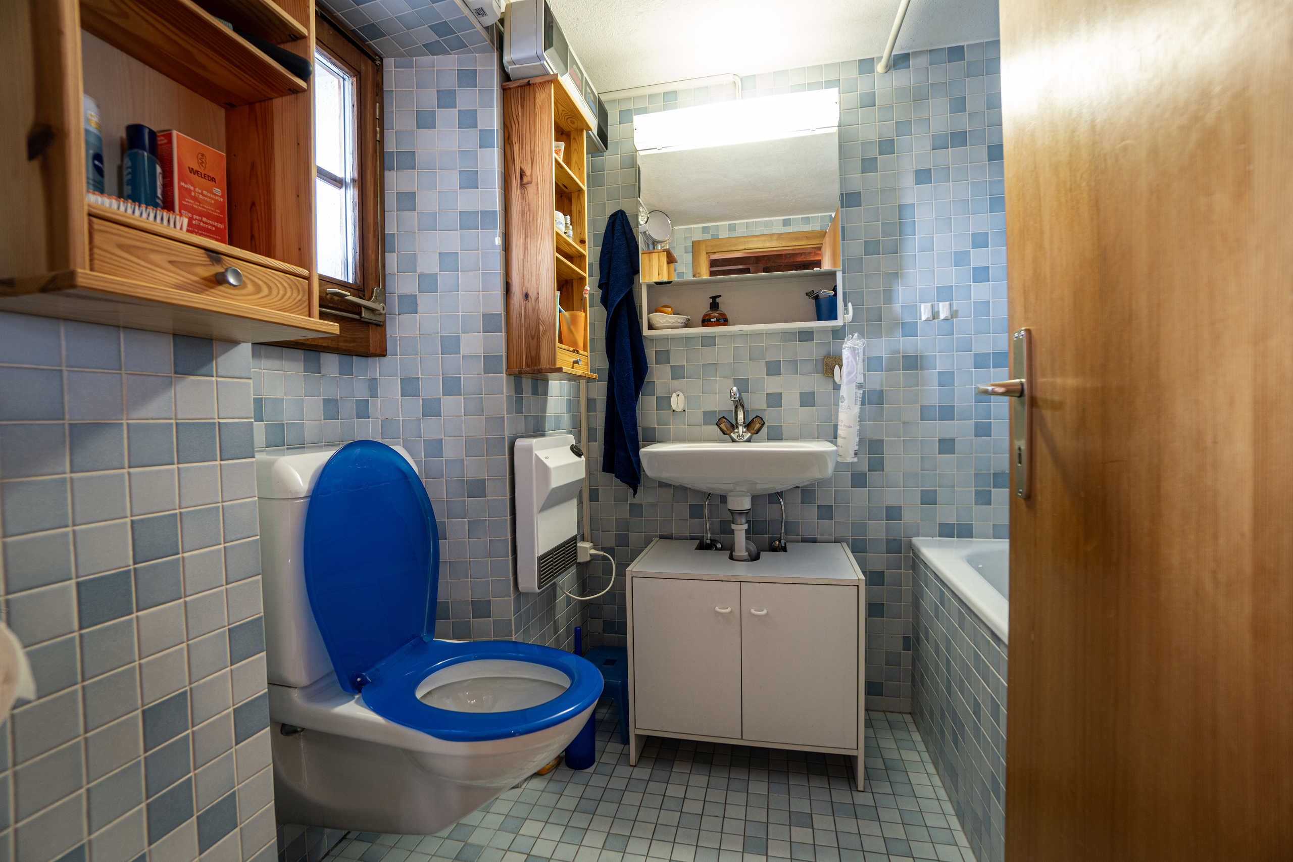 Kleines Badezimmer mit blauem Fliesenbelag und WC