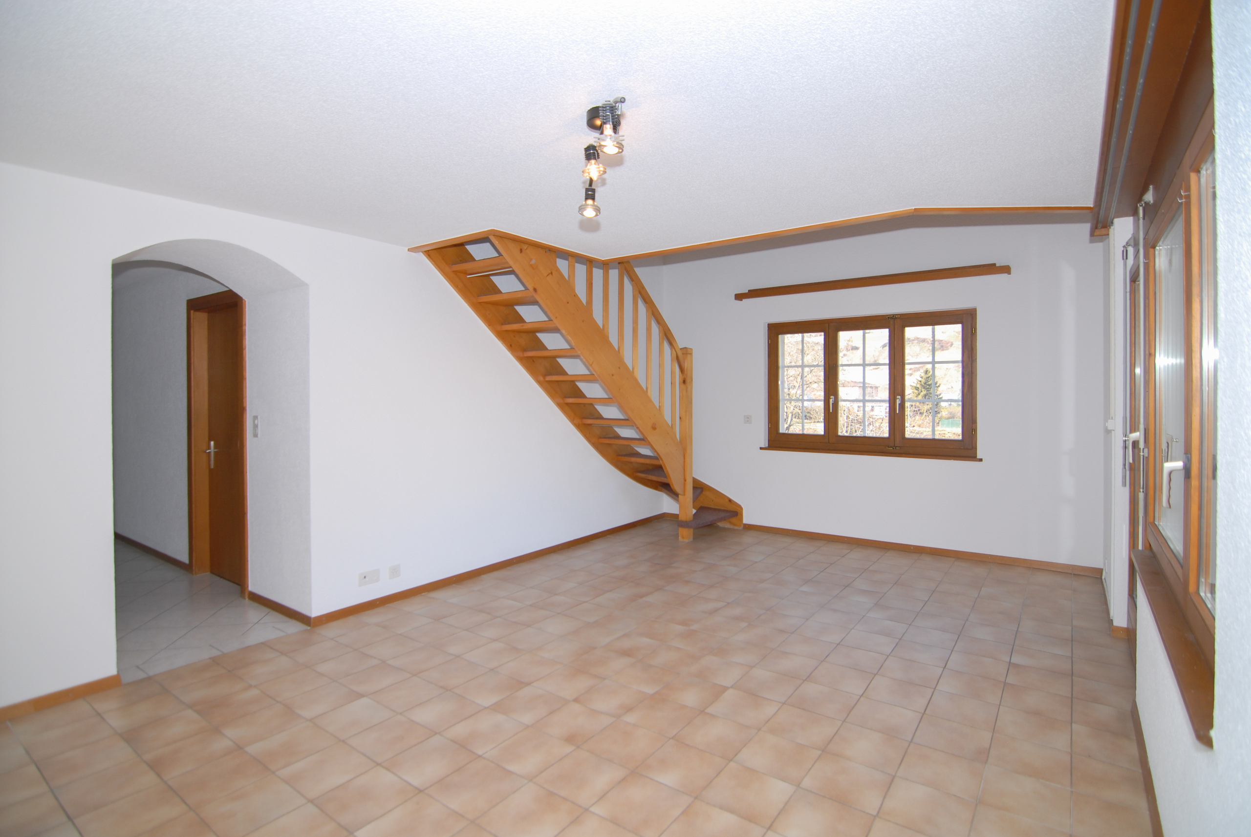 Heller Raum mit Treppe und Fliesenboden