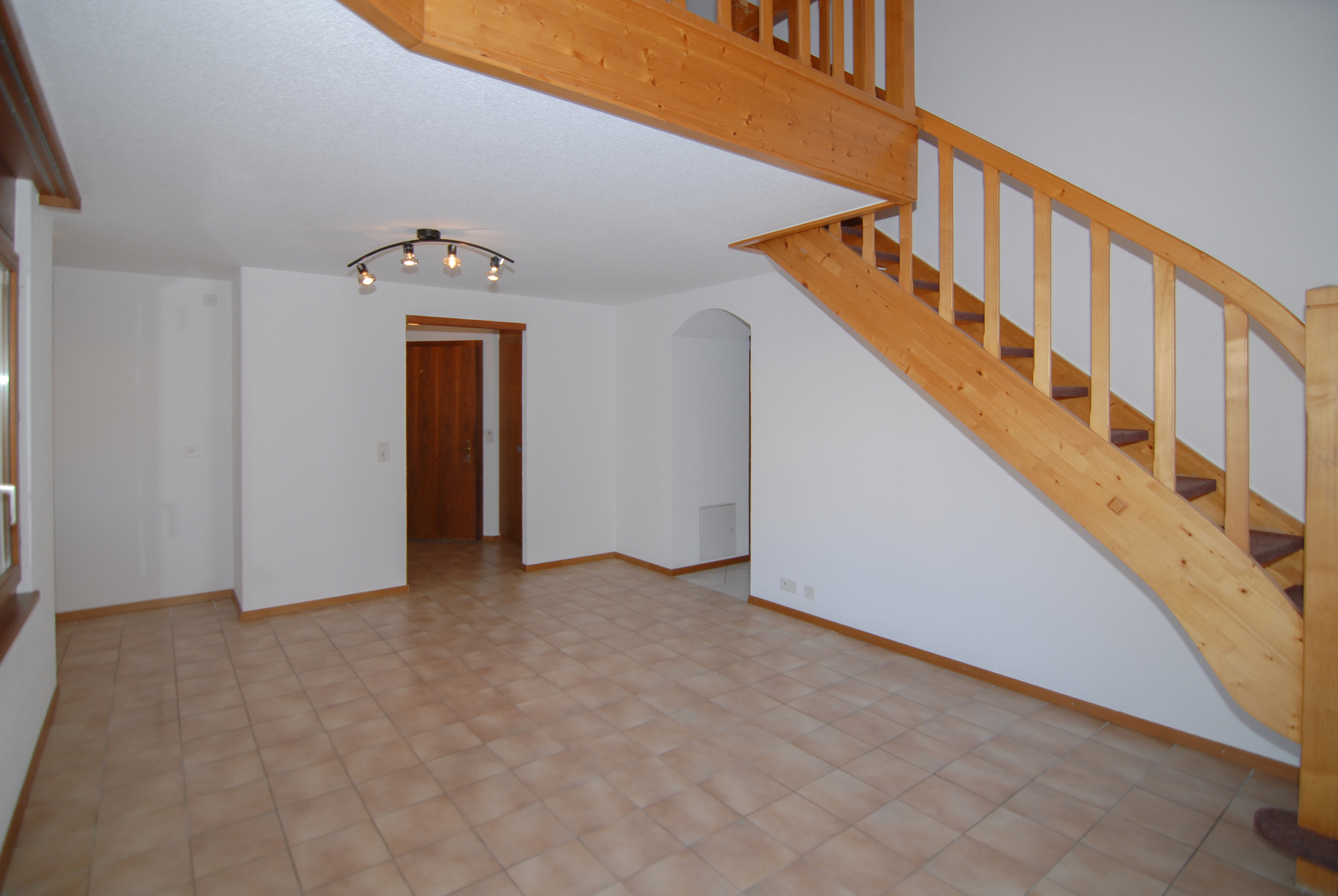 Leerer Wohnraum mit Holztreppe