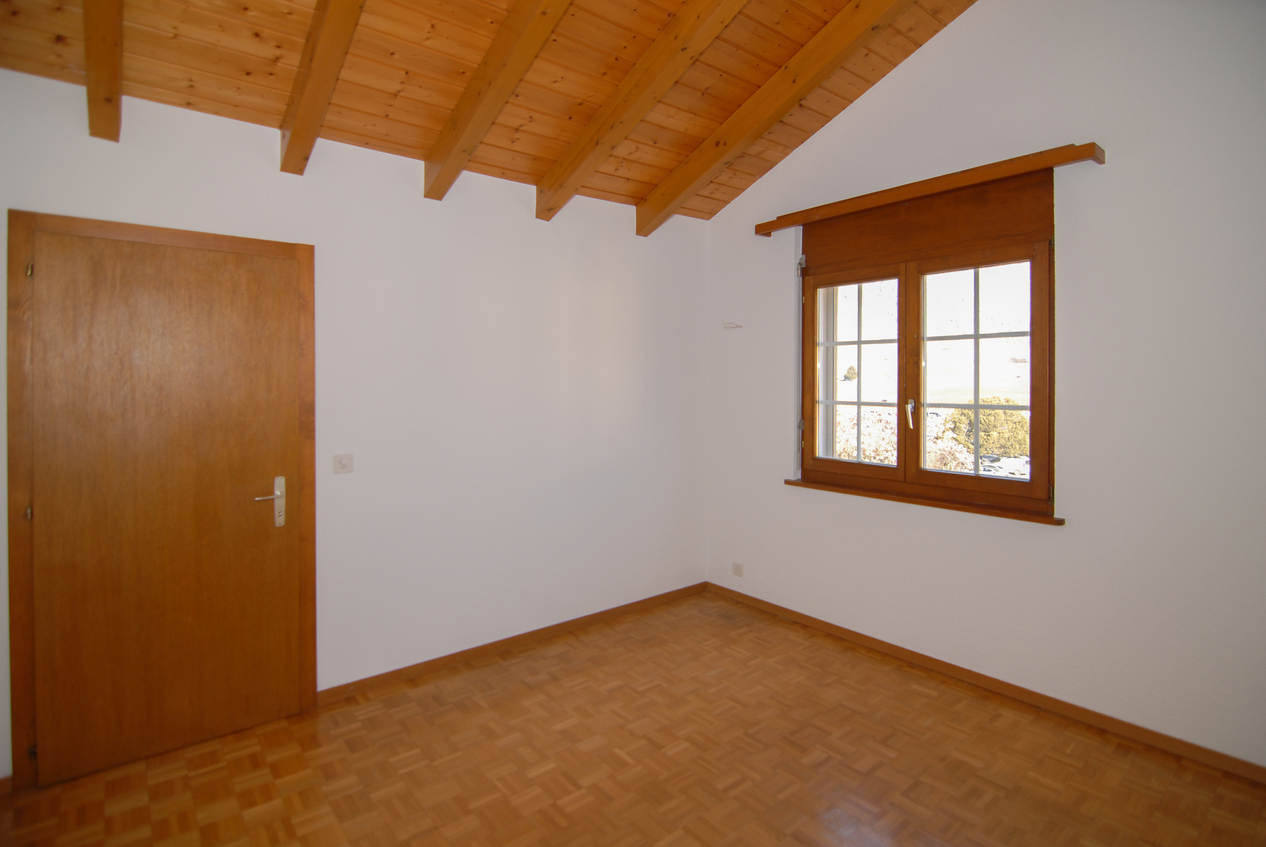 Leeres Zimmer mit Holzbalkendecke