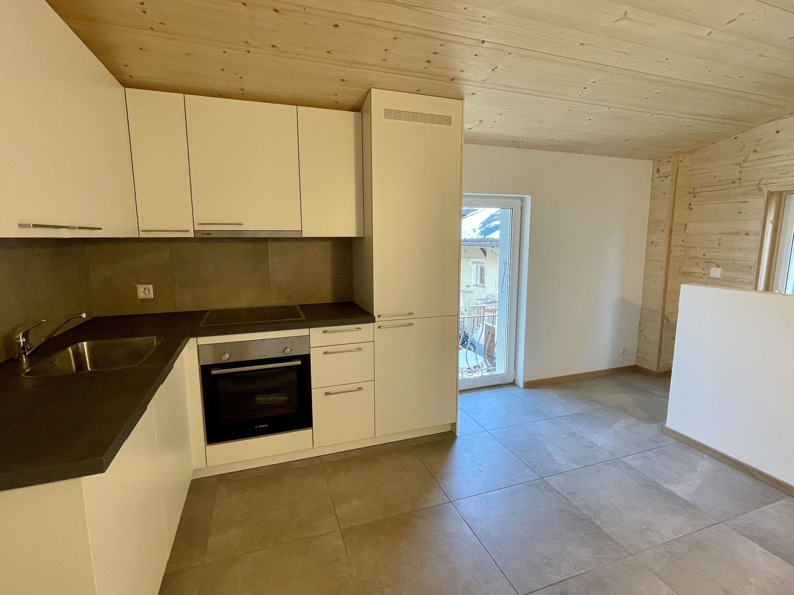 Offene Wohnküche mit heller Holzdecke