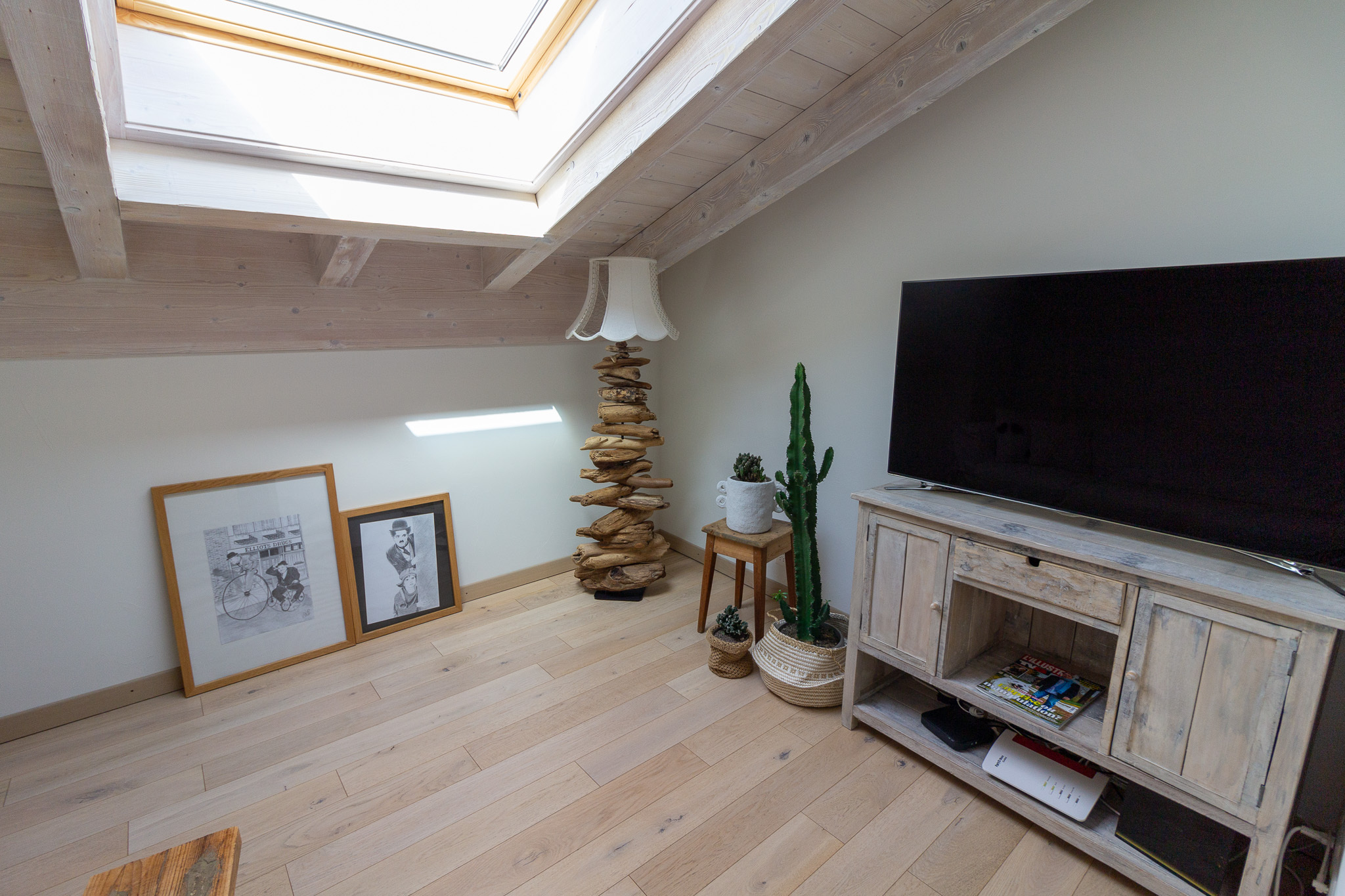 Dachzimmer mit hellem Holz und TV-Ecke
