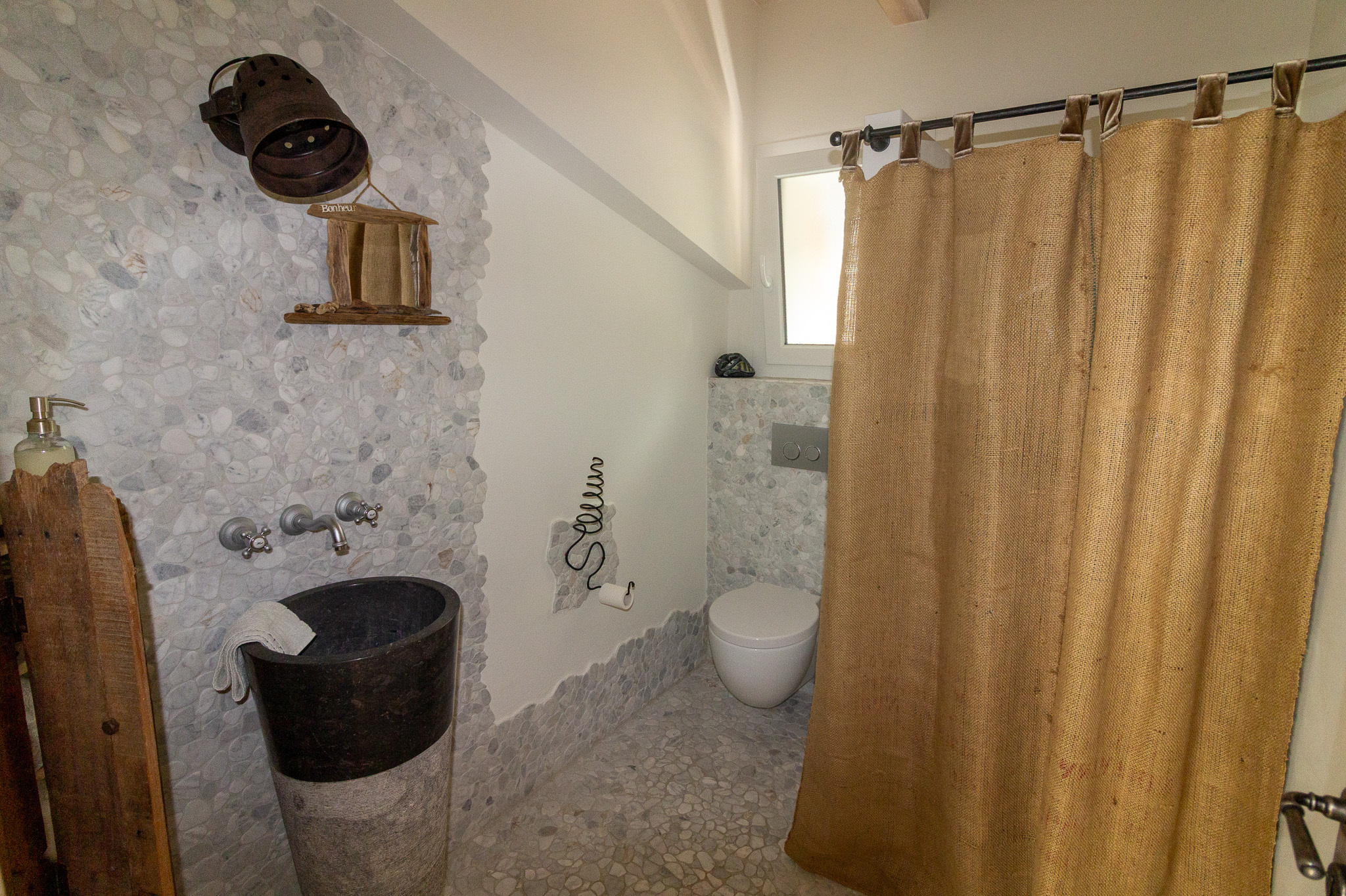Rustikales Badezimmer mit Natursteinoptik und Vorhangdusche
