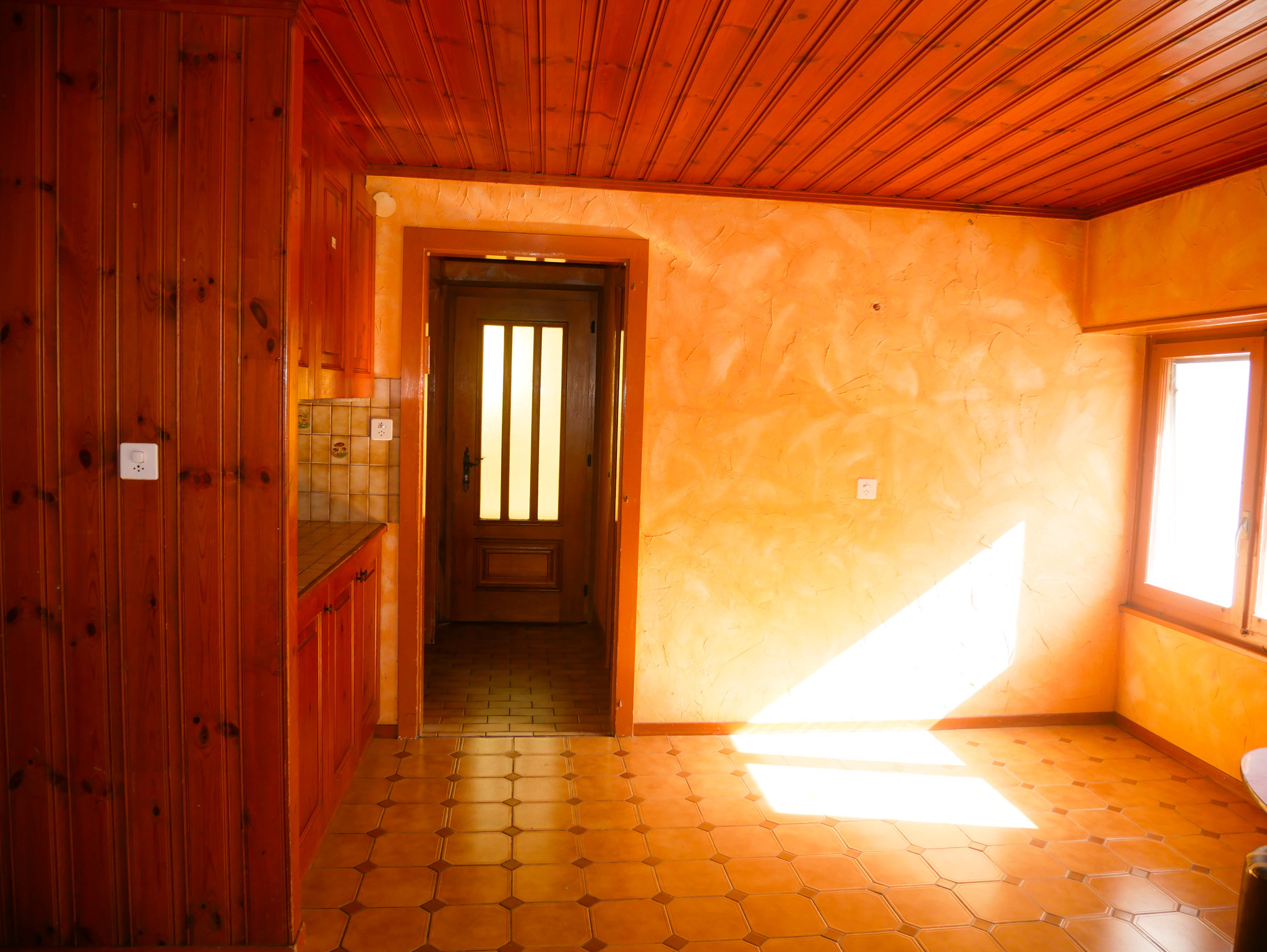 Warmer Flur mit Holzvertäfelung und Terrakottaboden