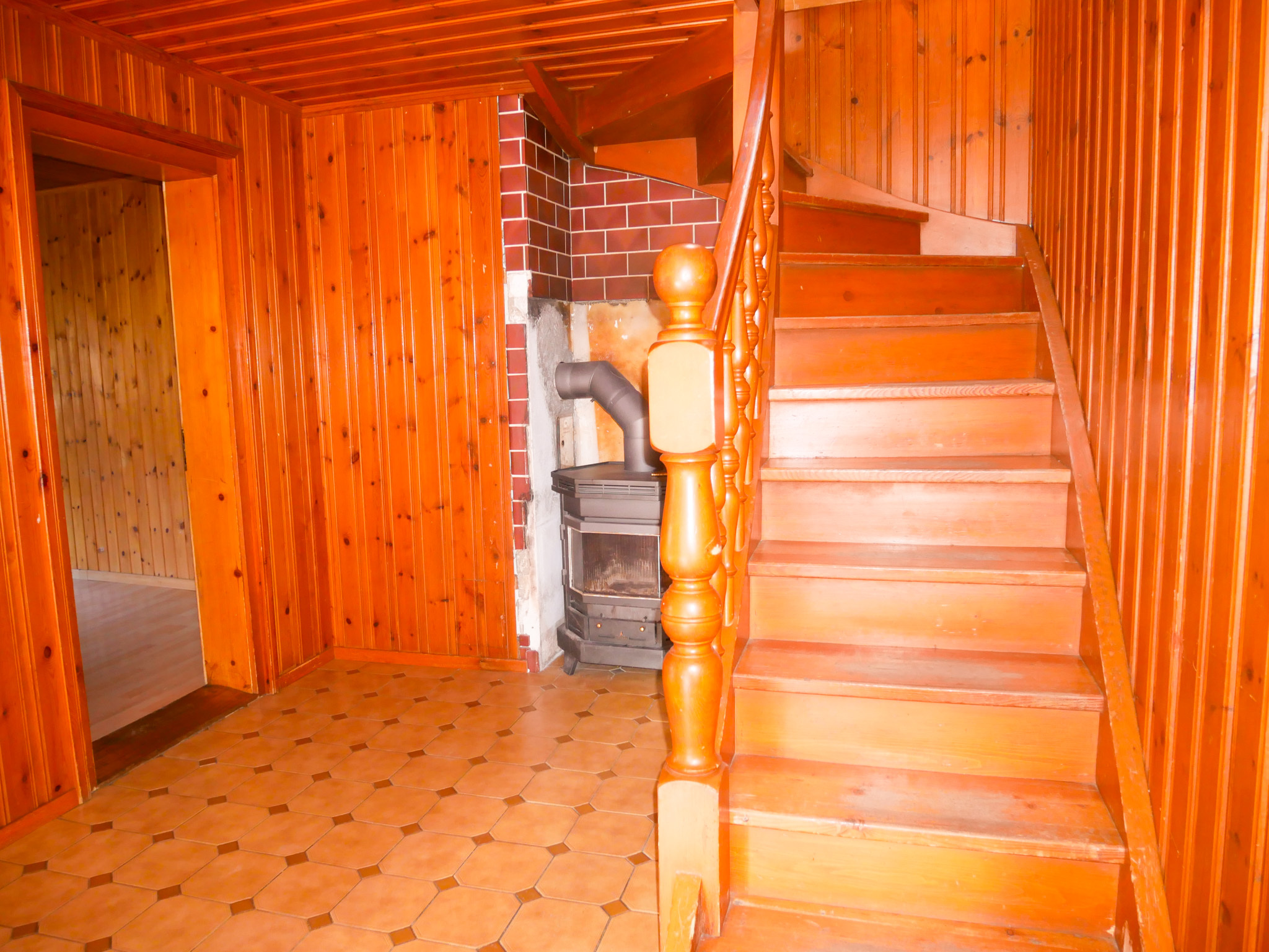 Holzverkleideter Flur mit Treppe und Ofen