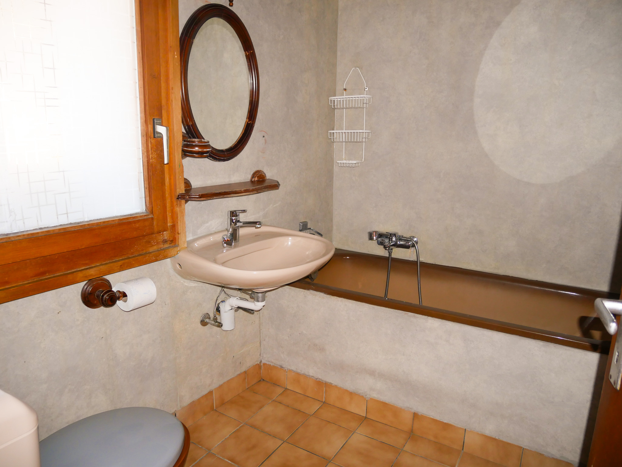 Kleines Badezimmer mit Badewanne und Waschtisch