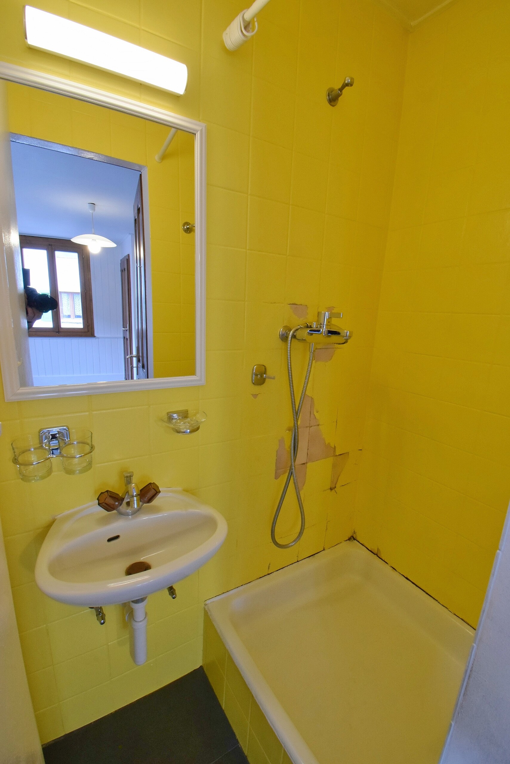 Gelbes Badezimmer mit Dusche und Waschbecken