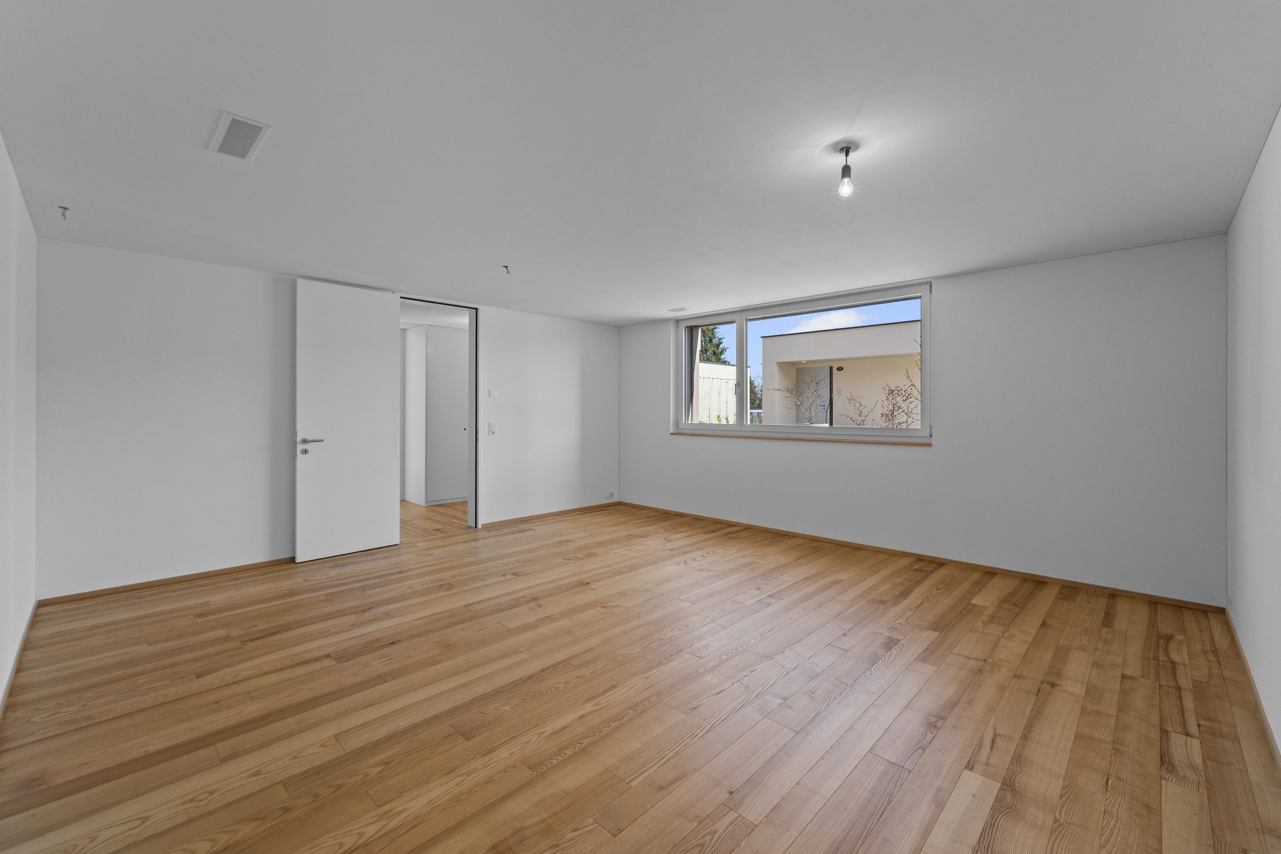 Leerer, heller Raum mit Holzboden
