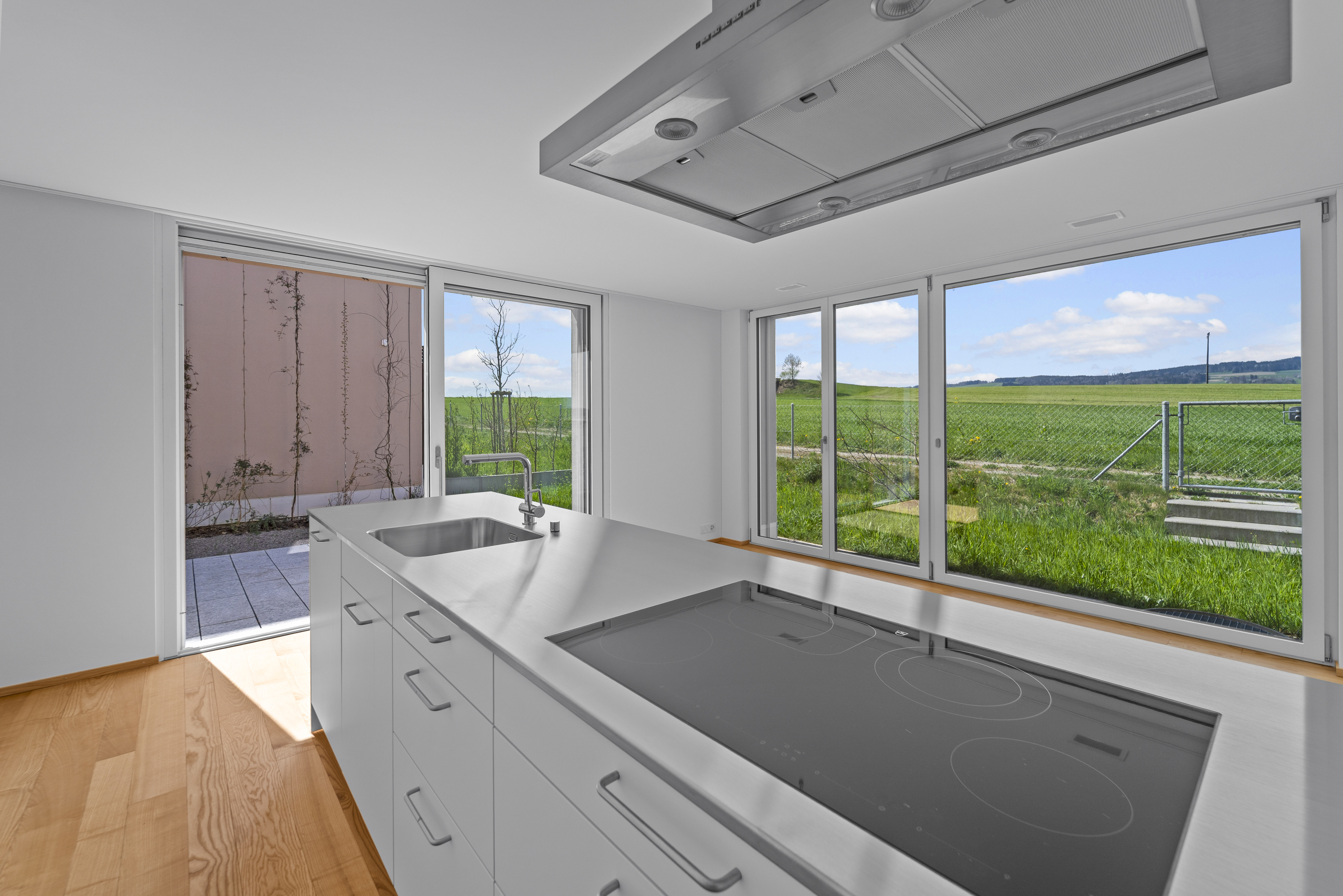 Moderne Küche mit großem Fensterfront-Ausblick