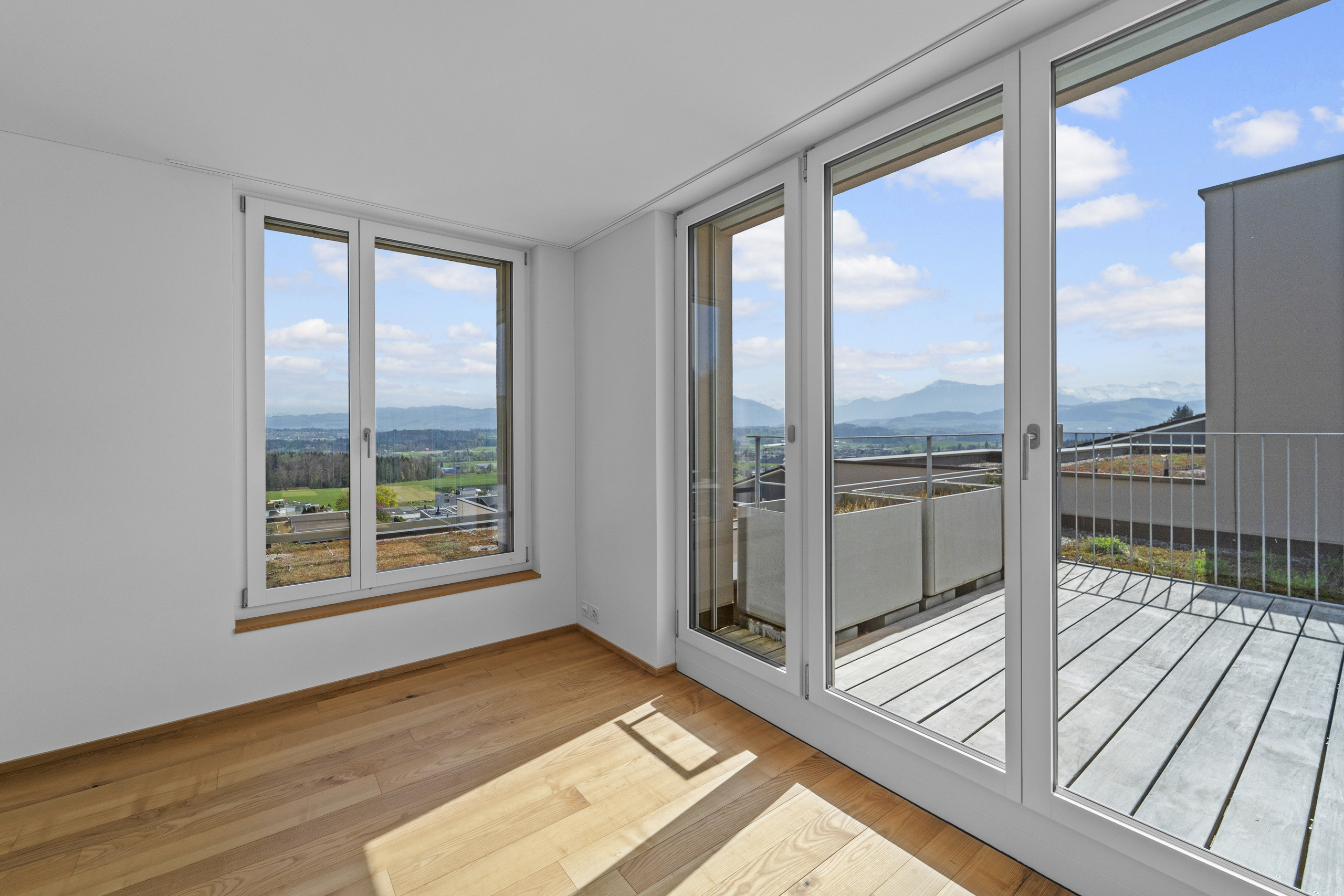Leeres Zimmer mit Panorama-Glasfront und Balkon