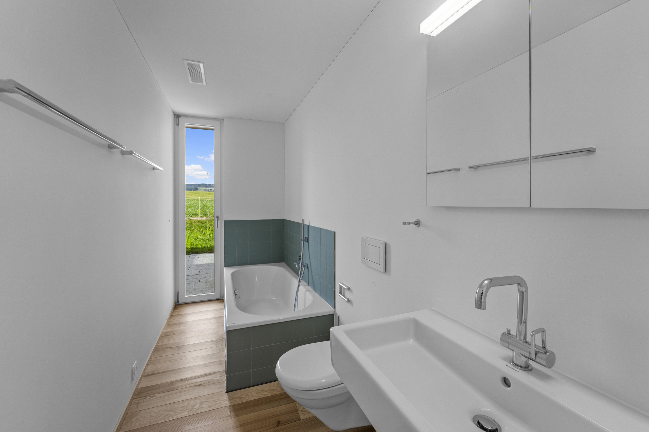 Modernes Badezimmer mit Badewanne und Blick ins Grüne