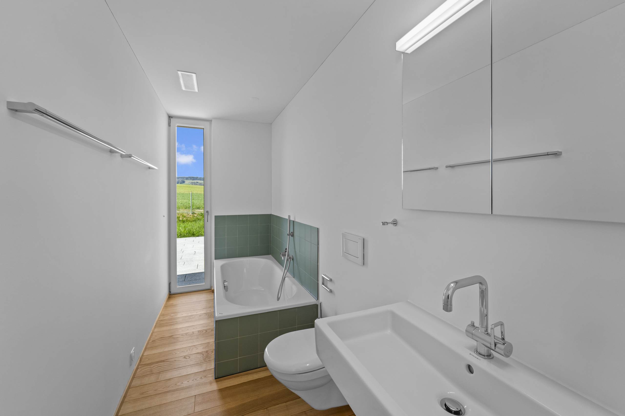 Schmales modernes Badezimmer mit Wanne, WC und Waschtisch