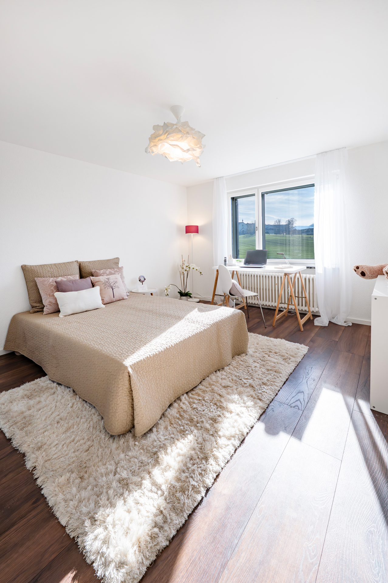 Helles Schlafzimmer mit Arbeitsplatz am Fenster
